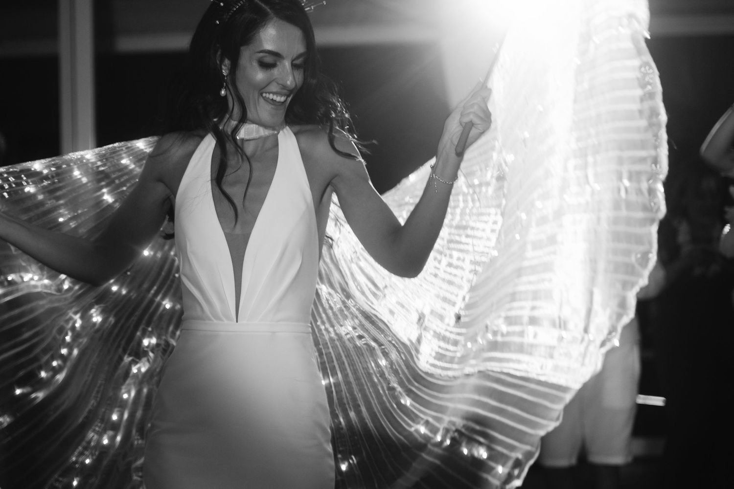 Wedding dancers illuminated by dramatic lighting effects creating silhouettes on the dance floor.