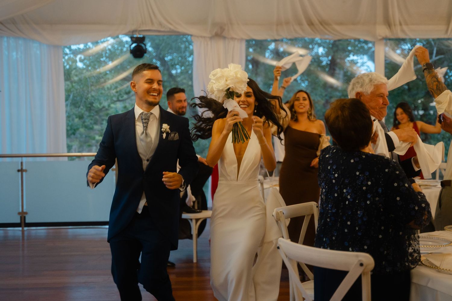 Wedding guests dance and celebrate together on the dance floor during a lively reception celebration.