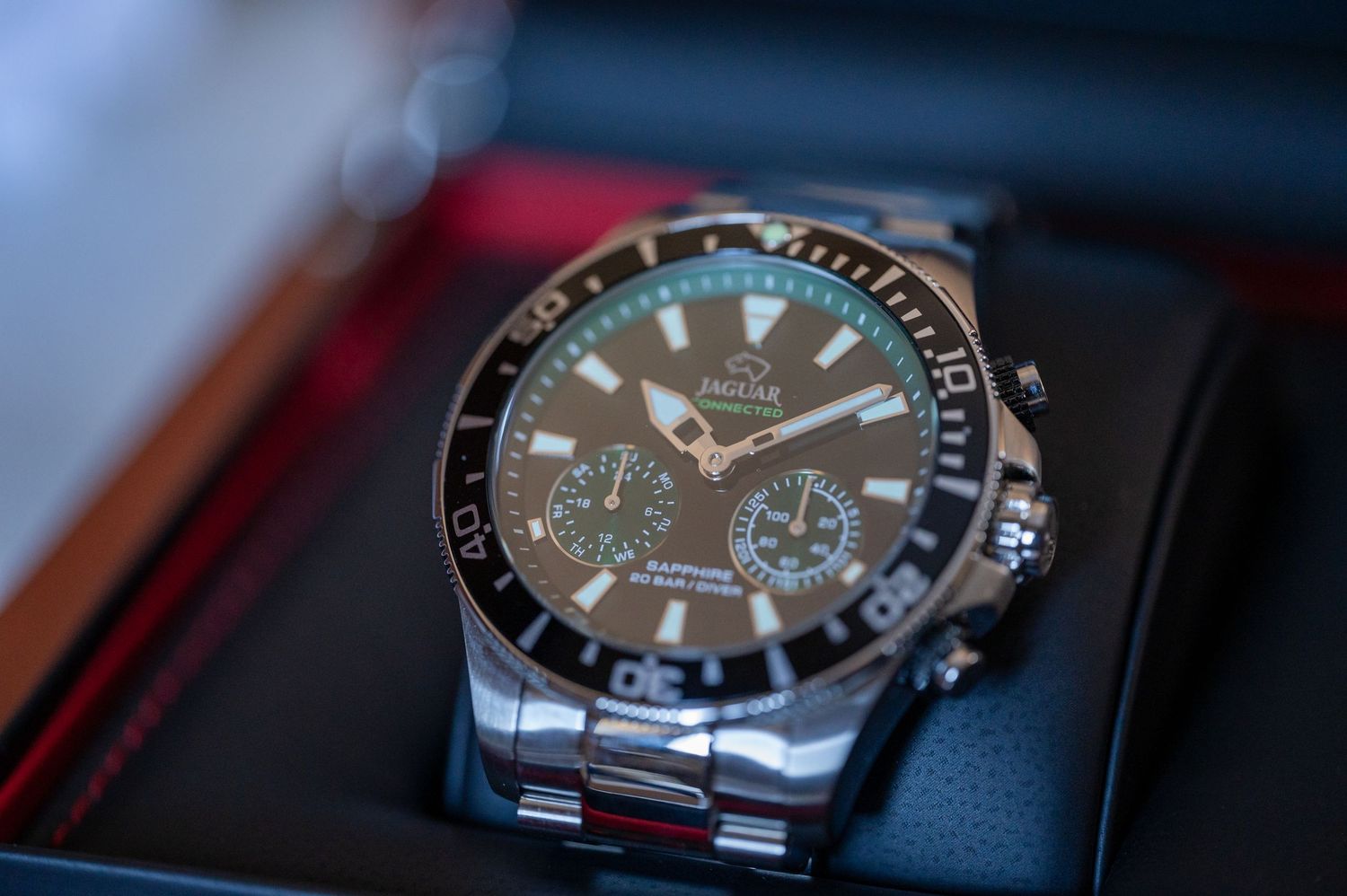 Luxury dive watch with black bezel and dial shown in multiple close-up angles on dark background.