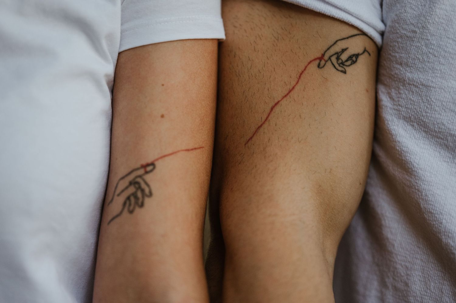 Close-up view of tattoos on bare skin with a white background.