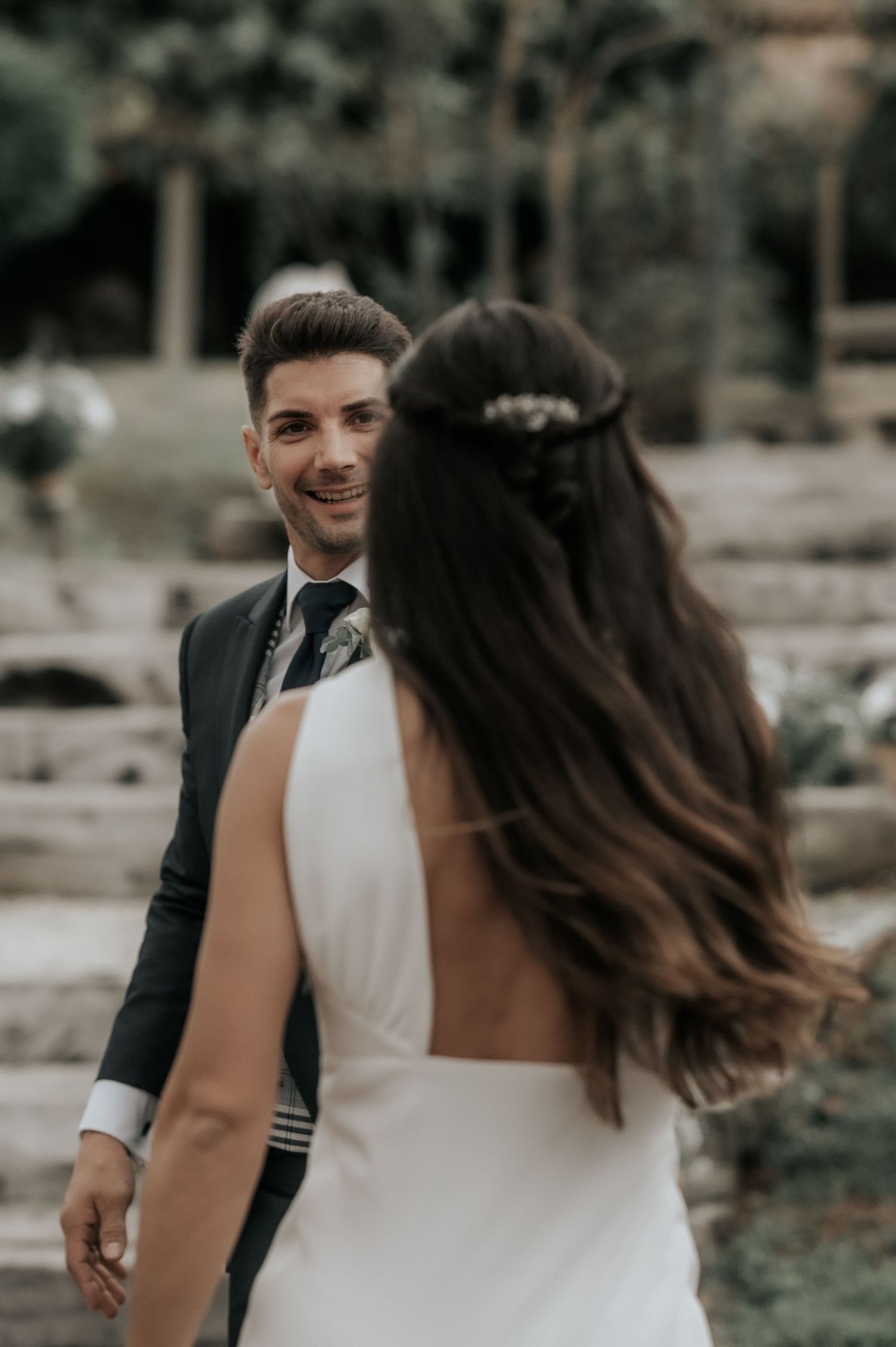 A couple in wedding attire share a romantic moment together in an outdoor garden setting.