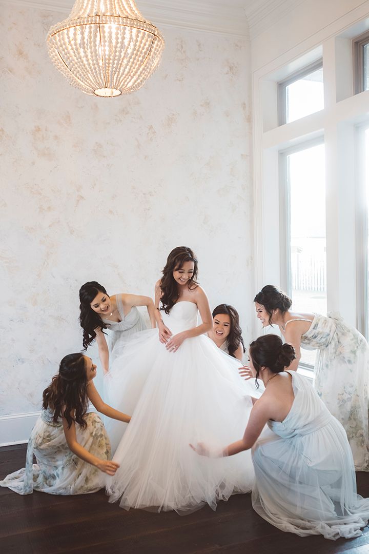 new orleans wedding photography bridesmaid helping bride get into dress. beautiful, creative, stylish.