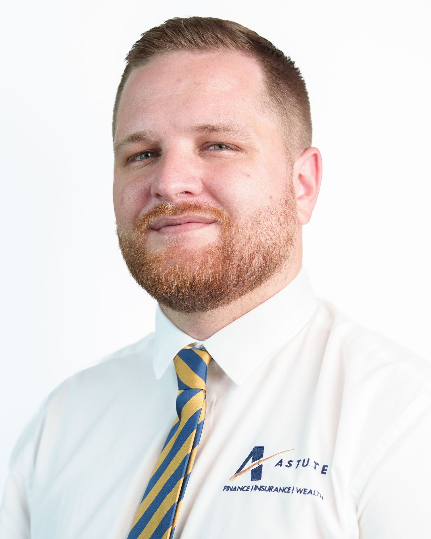 Professional headshot of a smiling man with red beard wearing a white Astute Finance shirt and striped tie.
