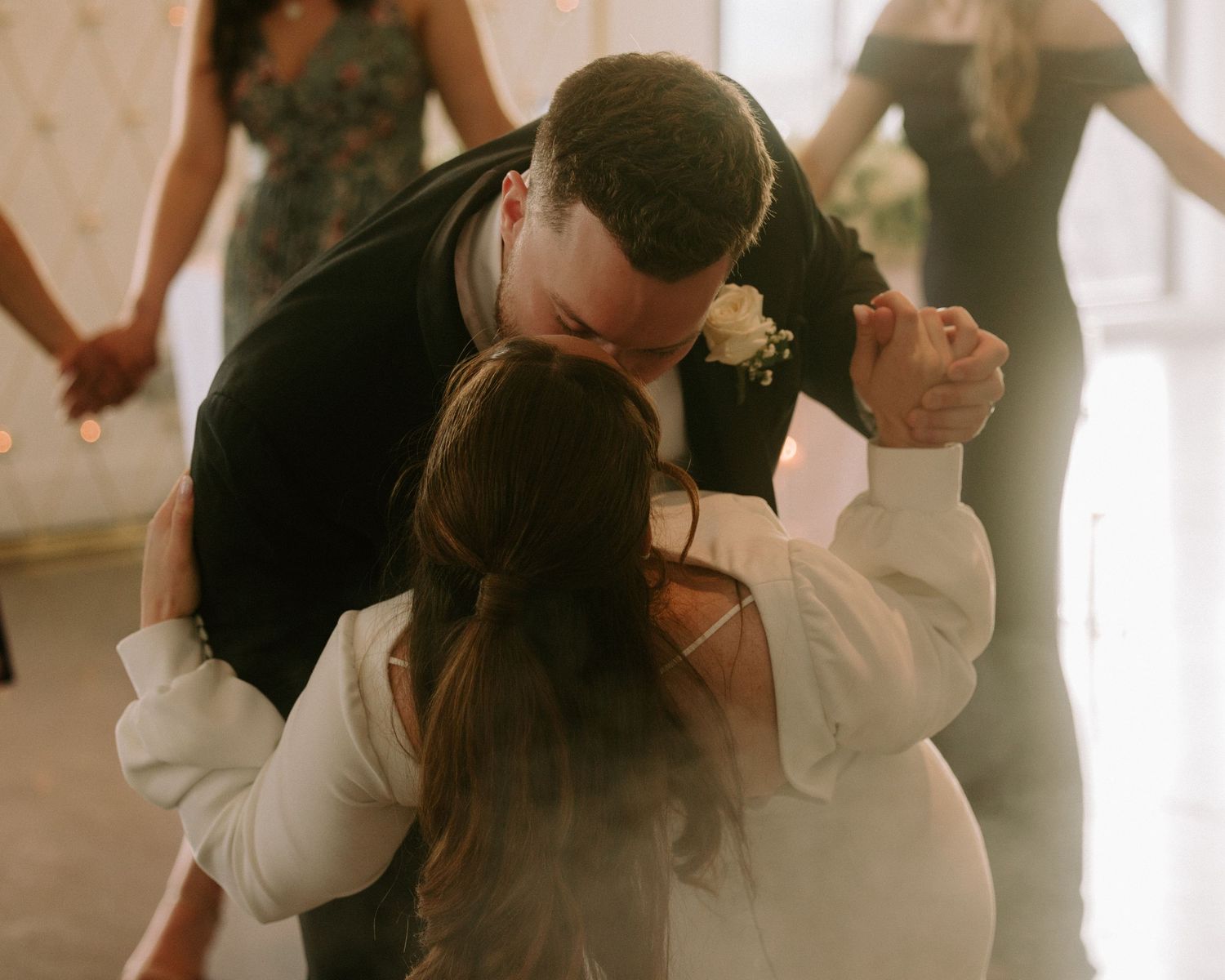 Bride and groom share a romantic first dance kiss at their elegant wedding reception.