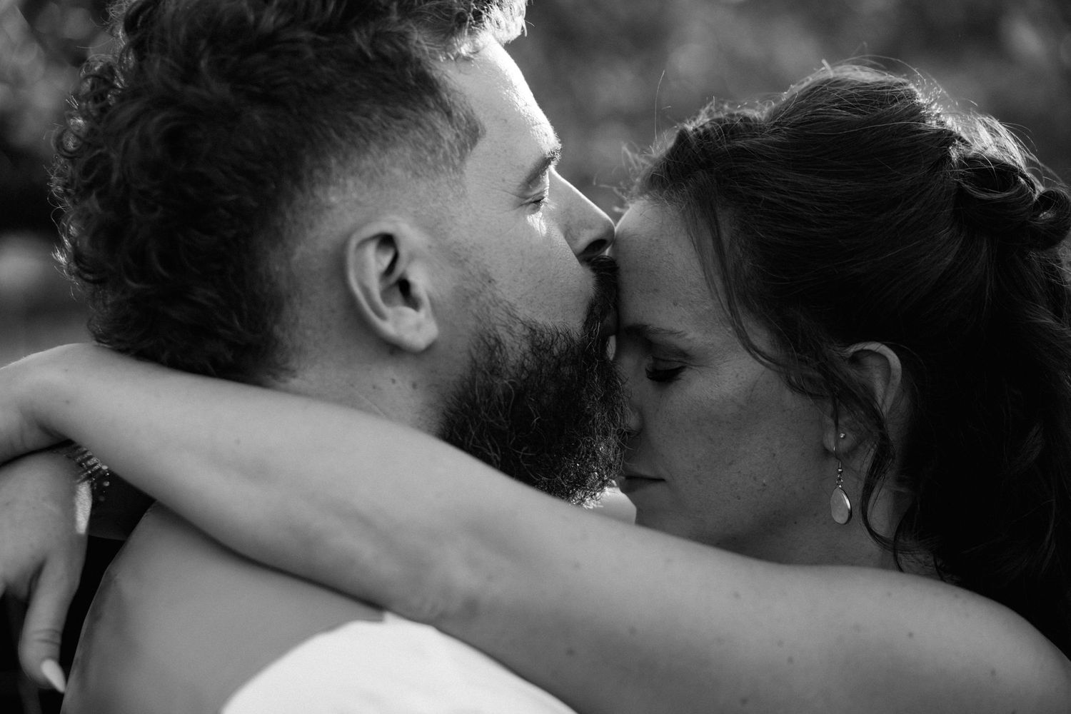 Intimate black and white close-up of bride and groom almost kissing on wedding day.