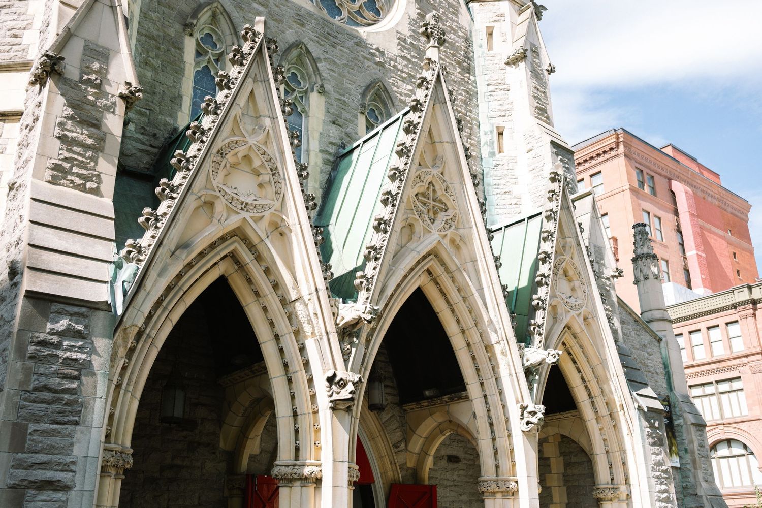 Gothic stone church facade with ornate pointed arches and decorative carvings.