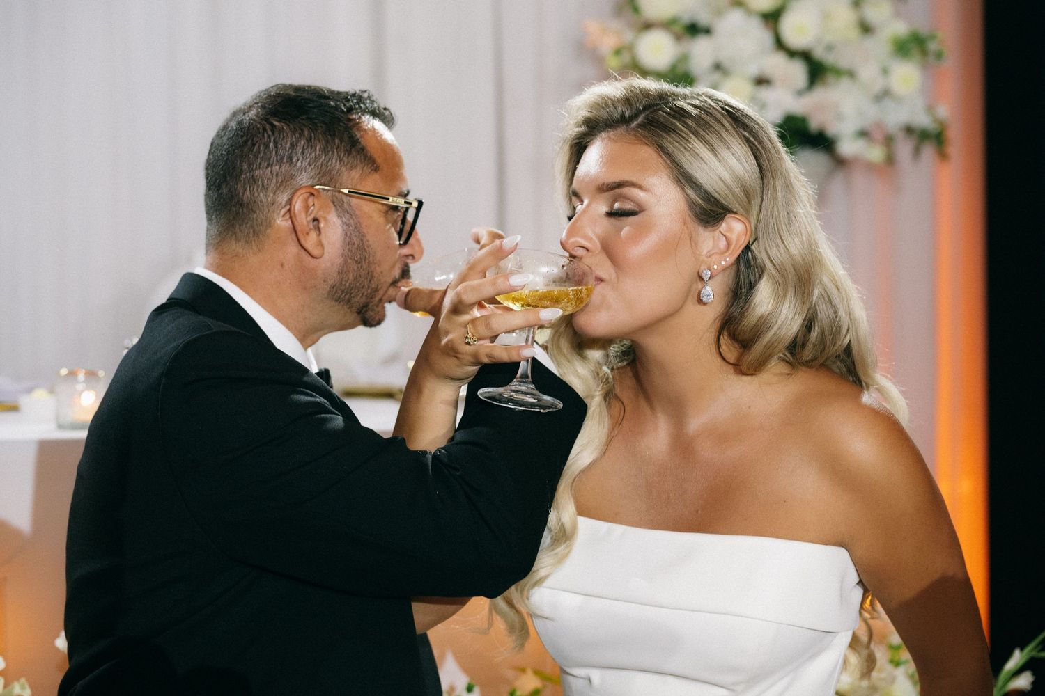Bride and groom sharing a champagne toast at their wedding reception dinner.