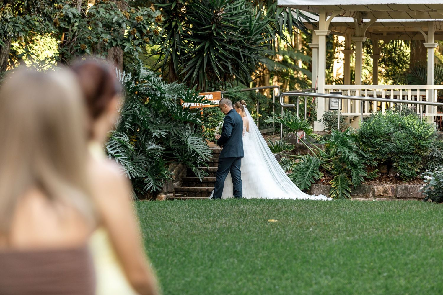 Bride and groom share intimate first look moment in lush garden wedding venue.