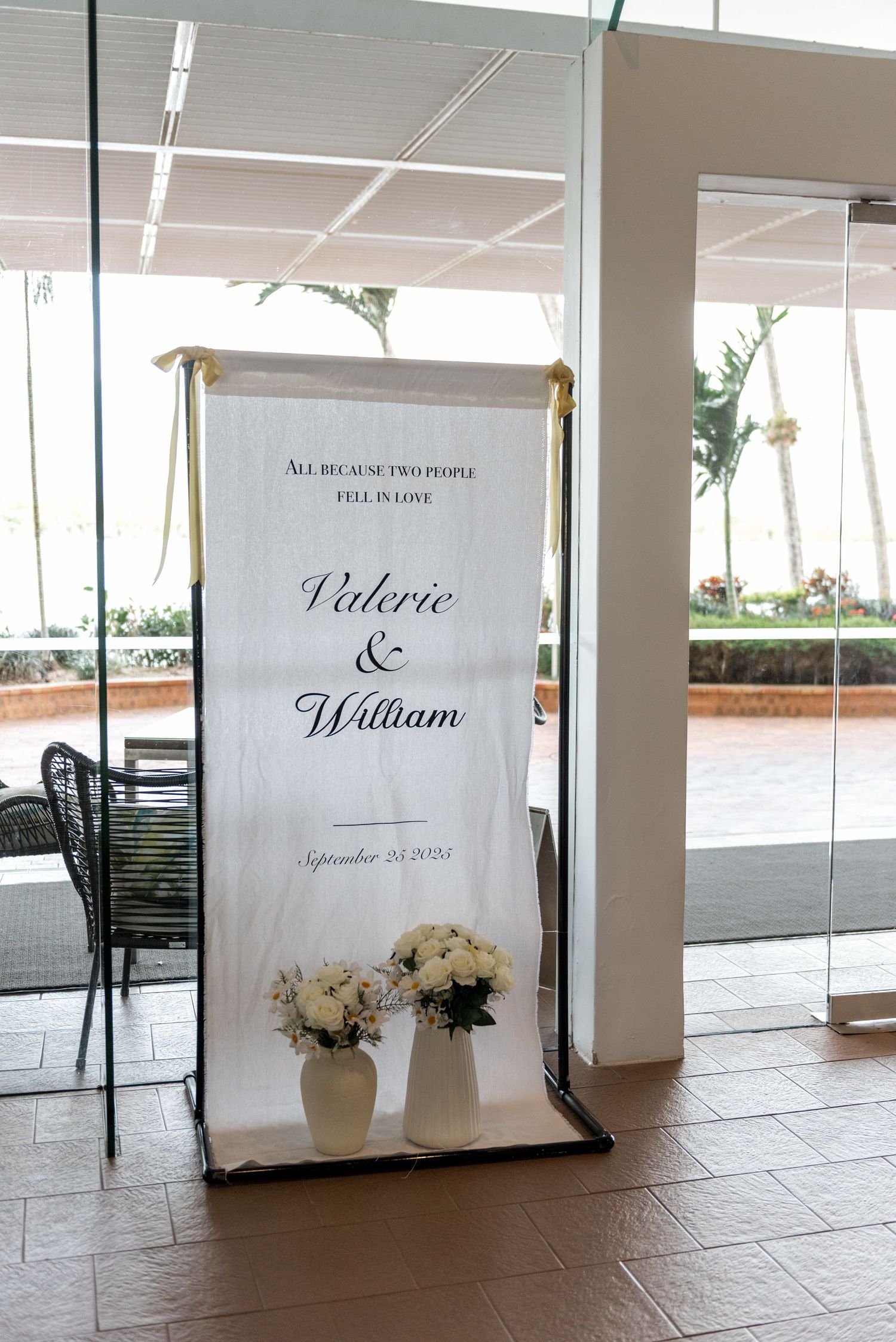 Wedding welcome sign reading Valerie and William September 20 2024 with white floral decor.