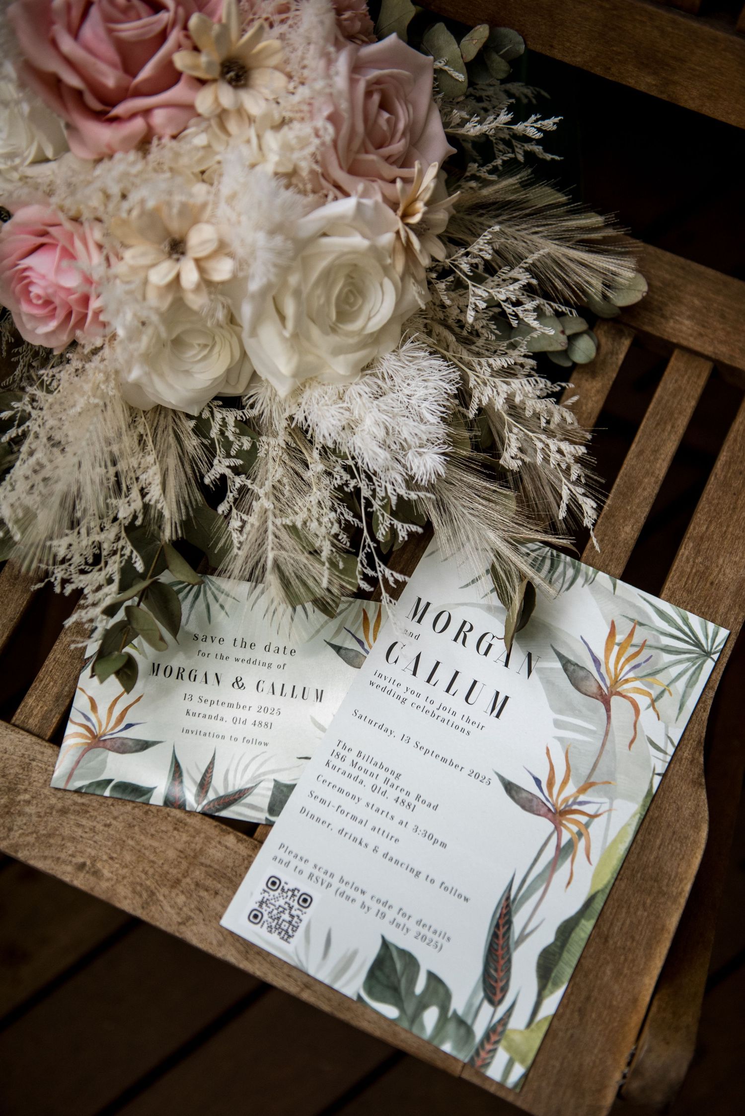 Tropical botanical wedding invitation for Morgan and Callum beside a blush and white bridal bouquet.