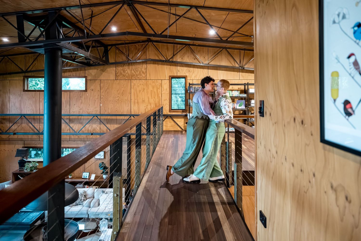 Couple embracing on a mezzanine level inside a modern rustic wooden building.