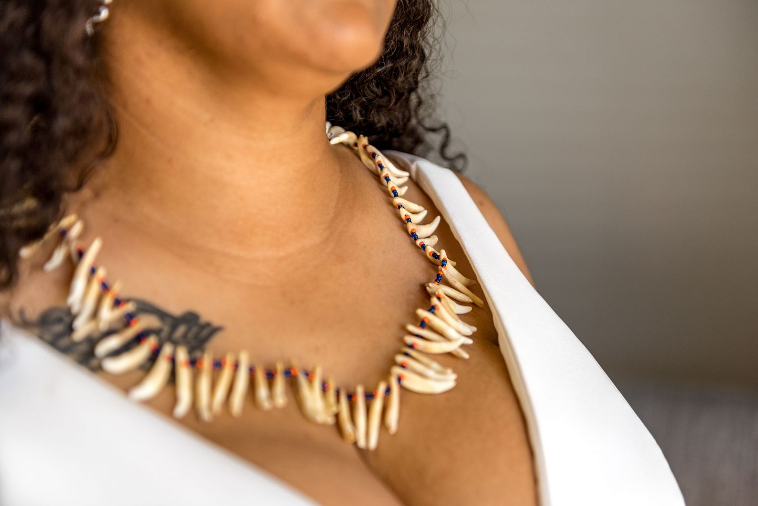 Close-up of bride wearing traditional shell necklace with white wedding dress.