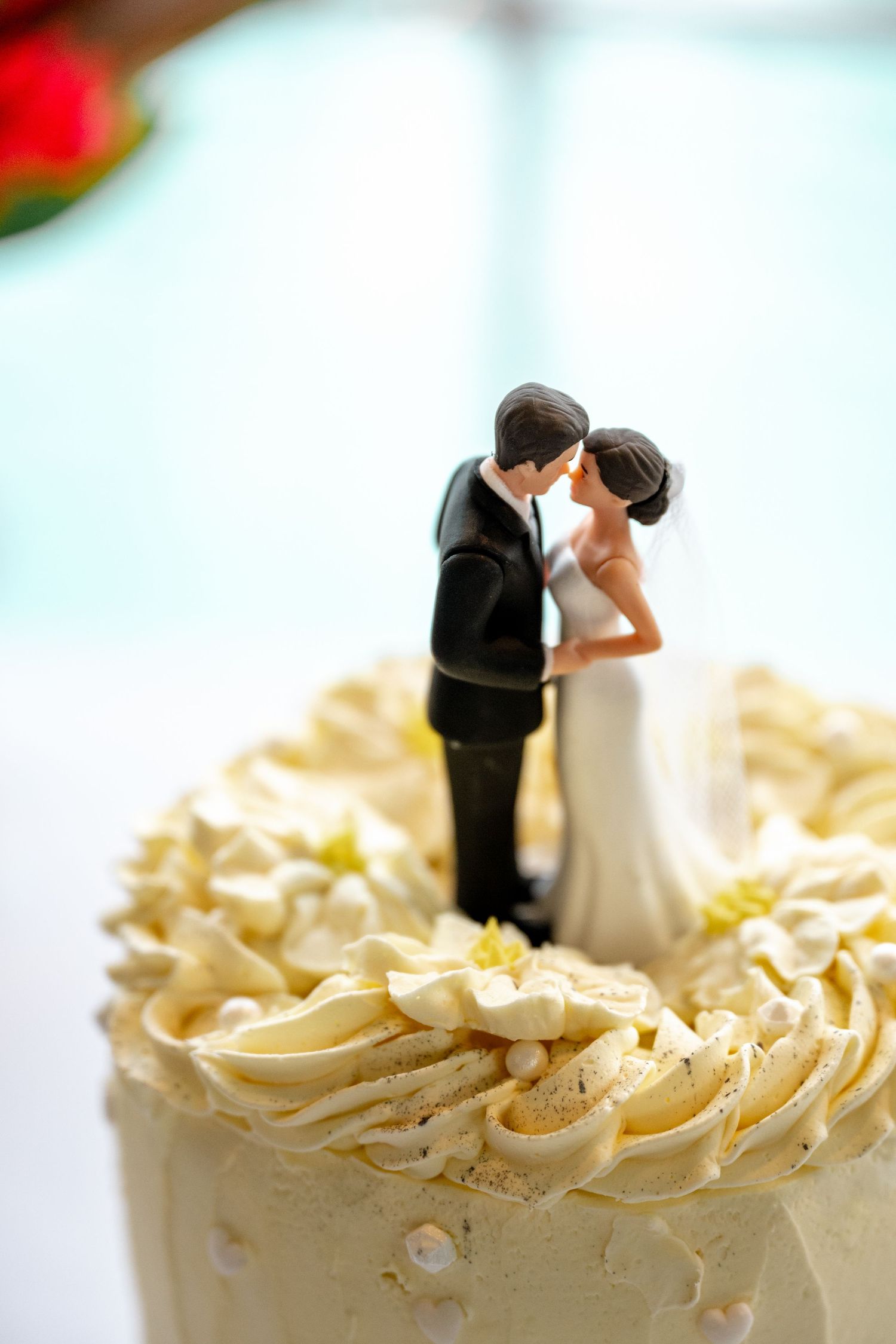 Classic white wedding cake topped with bride and groom figurine sharing a romantic kiss at Sheraton Grand Mirage Port Douglas.