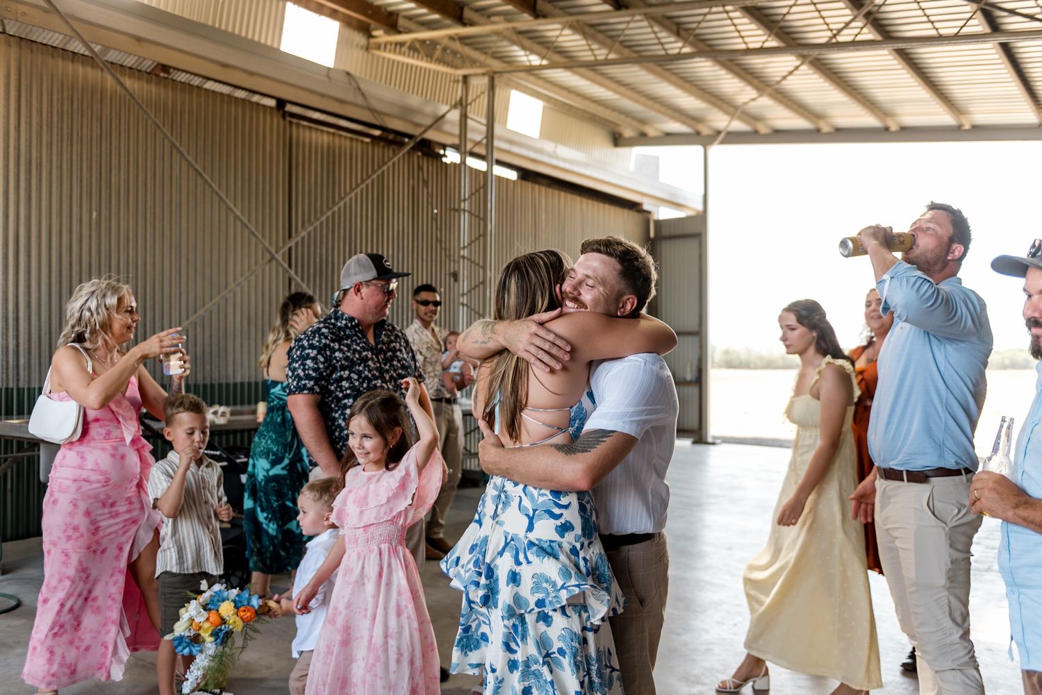 Bride receives warm hugs from guests during joyful barn wedding reception celebration.