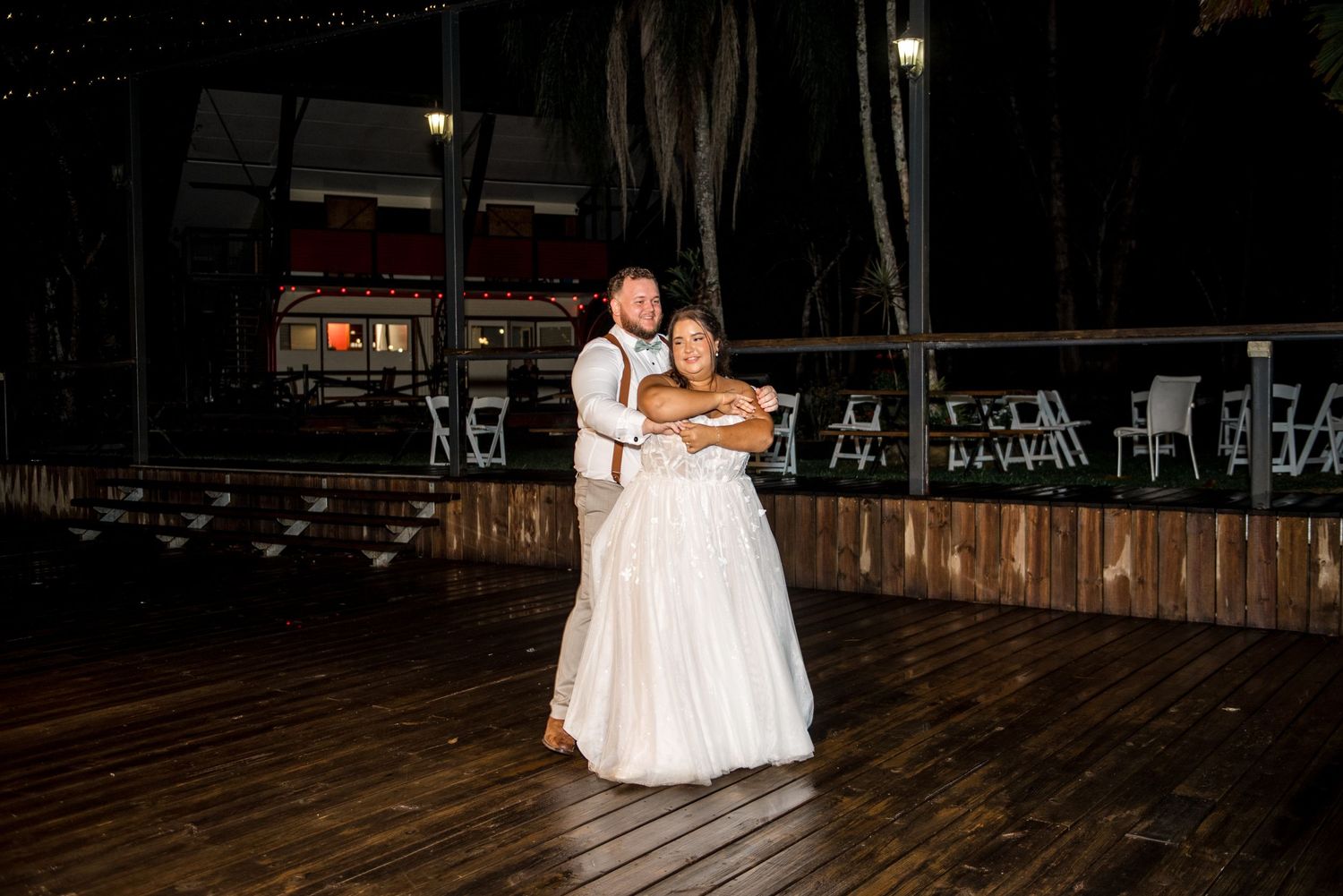 Bride and groom share an intimate slow dance outdoors at their evening wedding reception.