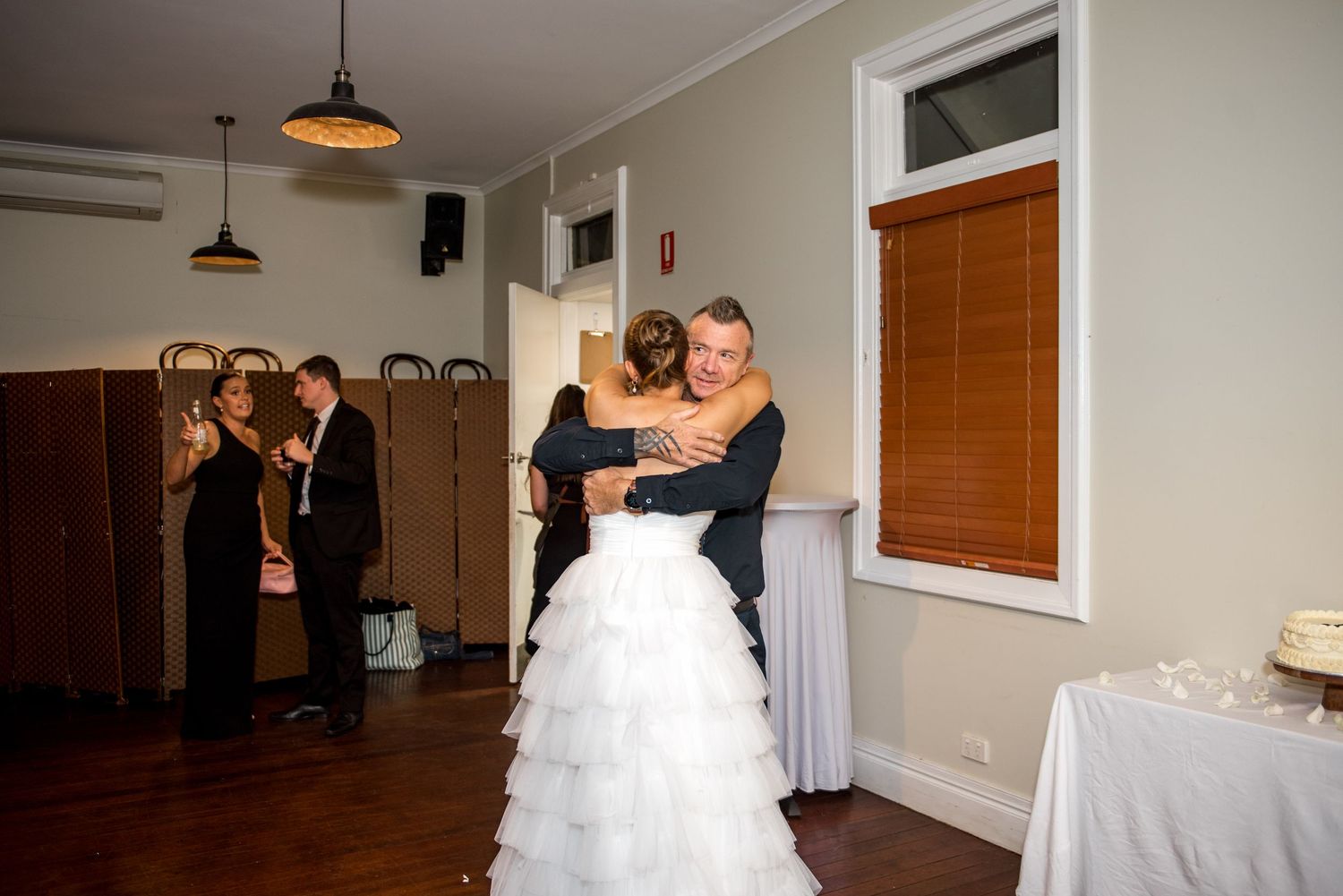 Bride and groom sharing a warm embrace on the dance floor at their wedding reception.