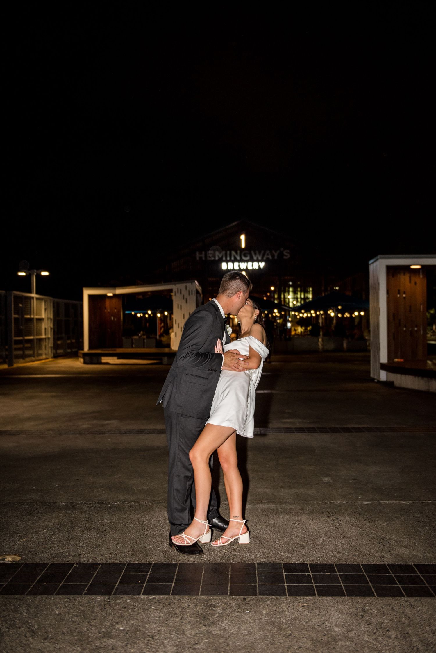 Newlyweds share a romantic kiss outside Hemingways Brewery on their wedding night.