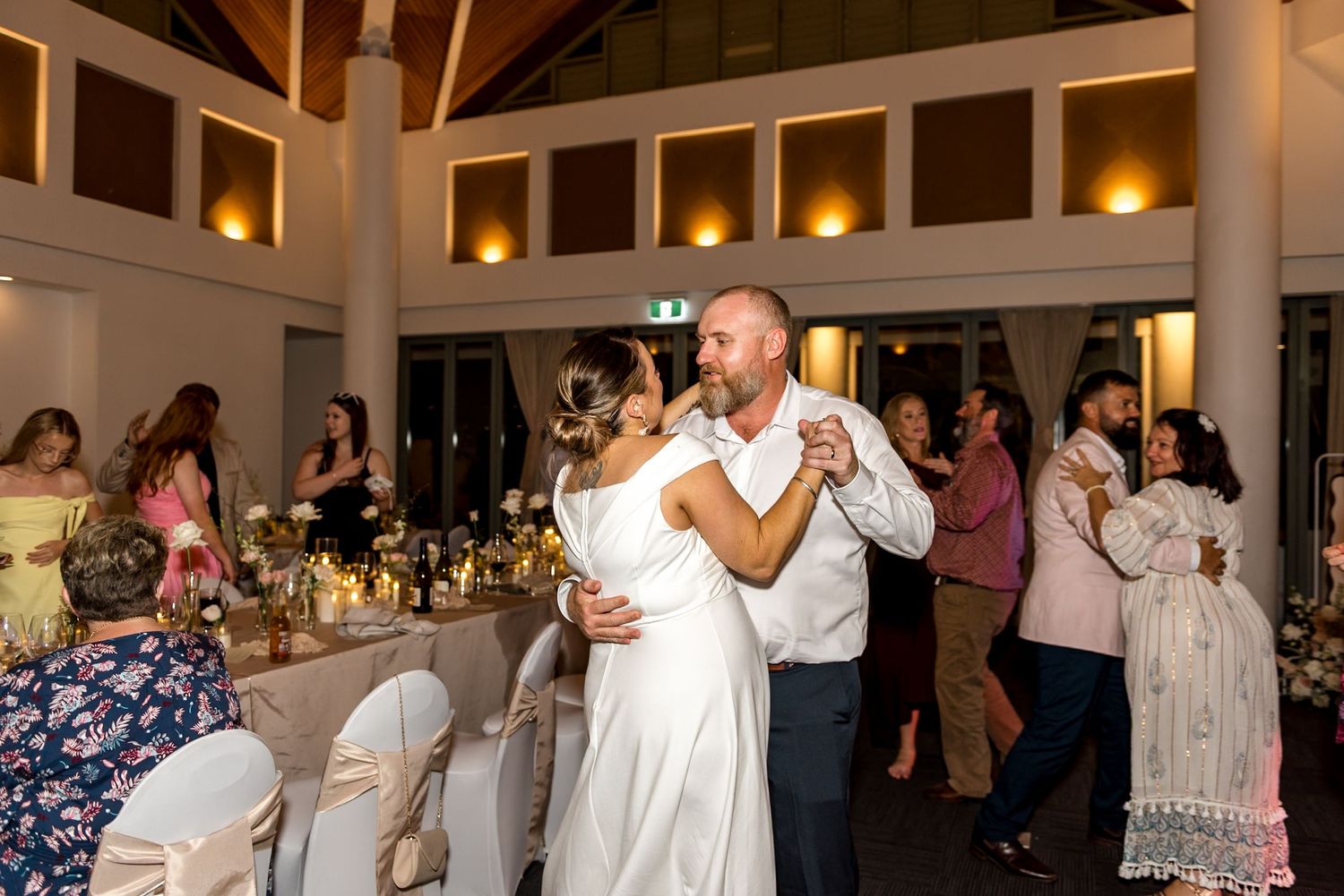 Bride and groom share their first dance at a beautifully decorated reception.