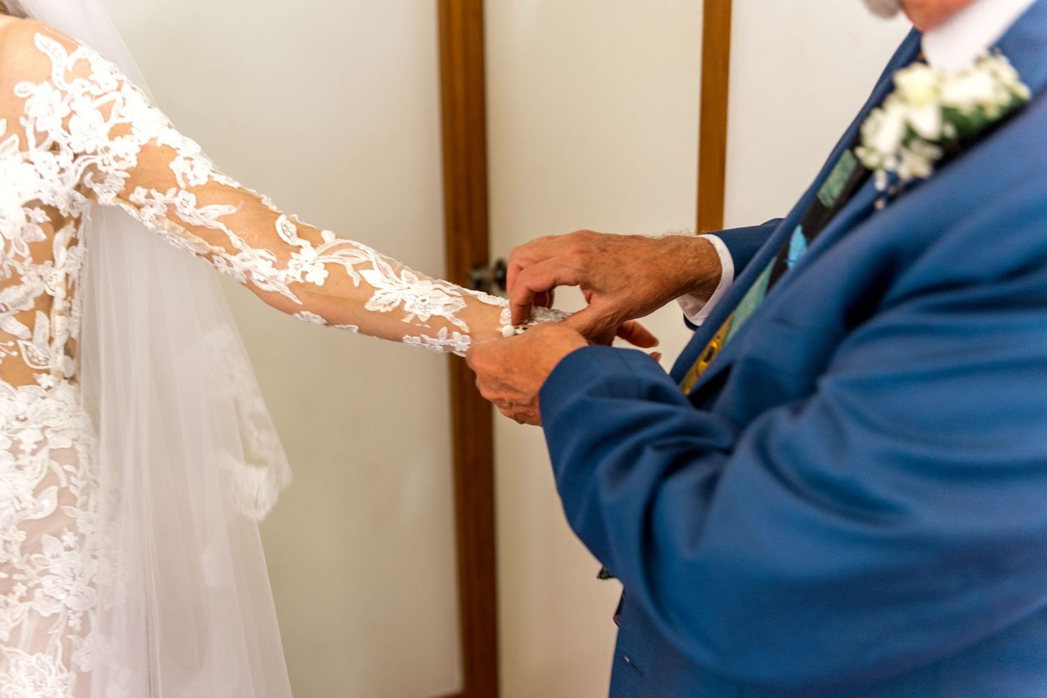 Father of the bride placing a wedding ring on the bride's finger during the ceremony.
