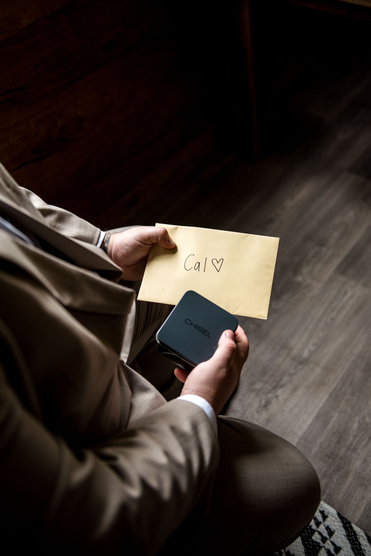 Close-up of person holding an envelope addressed to Cal with a heart symbol and a small box.