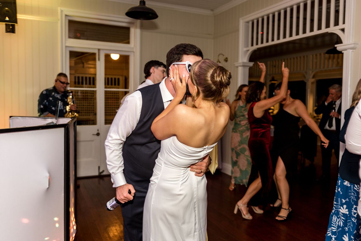 Bride and groom sharing a kiss on the dance floor at their wedding reception.