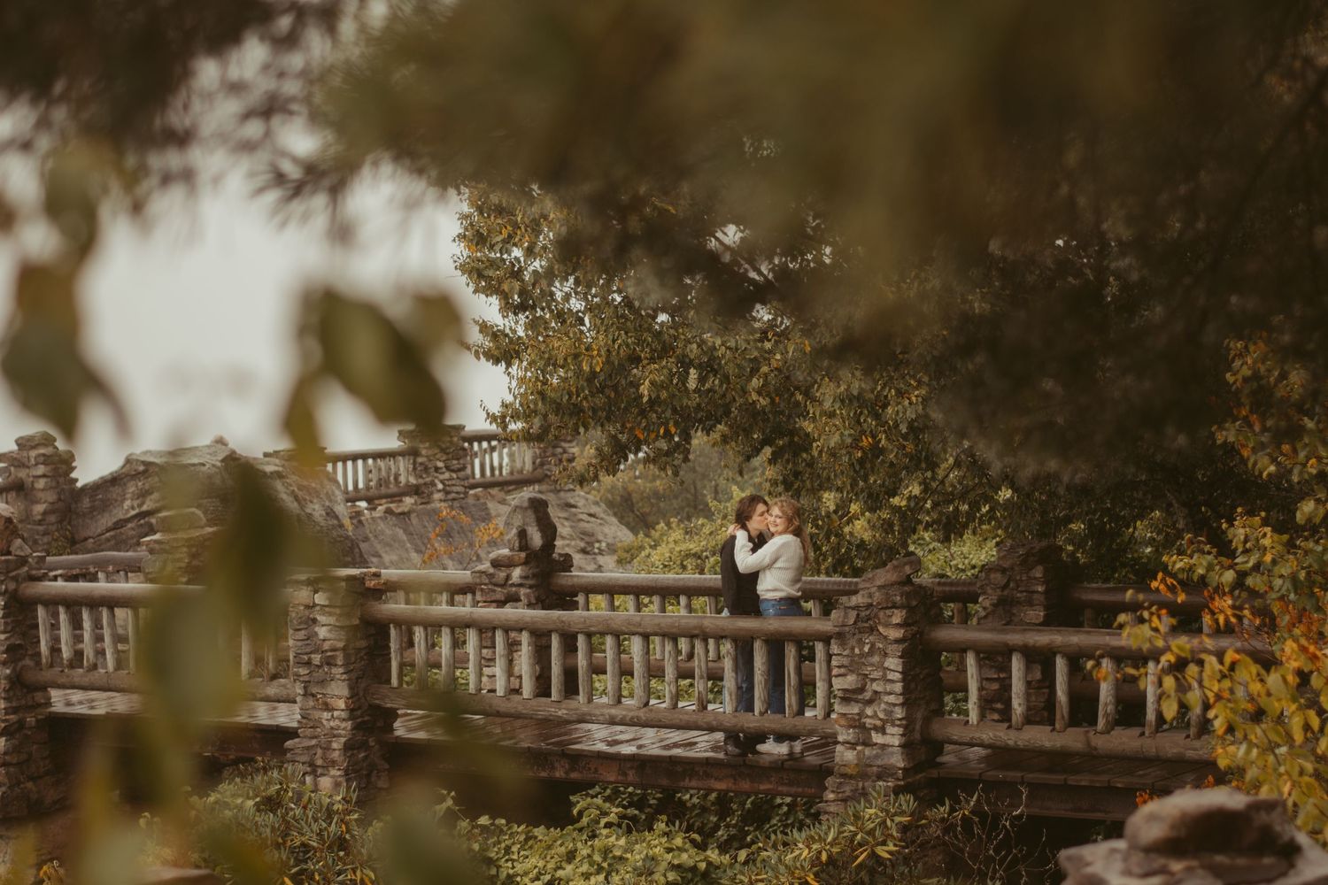 Stone balustrade and columns in an elegant garden setting with autumn foliage.