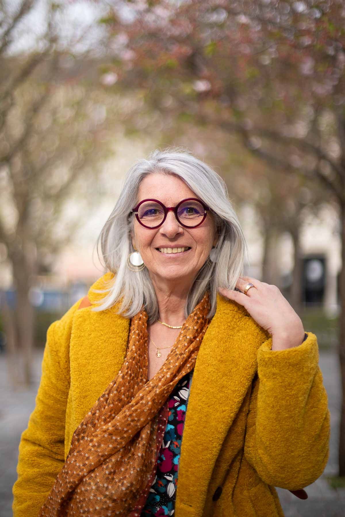 femme en extérieur aux cheveux blancs avec un manteau jaune, à Tours