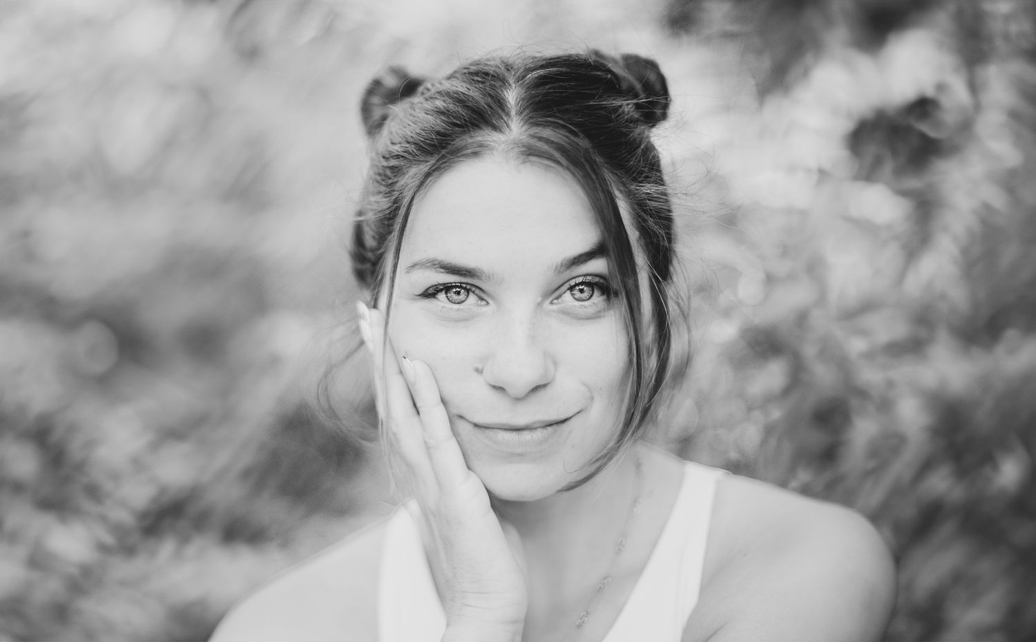 portrait d'une jeune femme regardant droit vers l'objectif, une main posée sur sa joue, shooting à Tours
