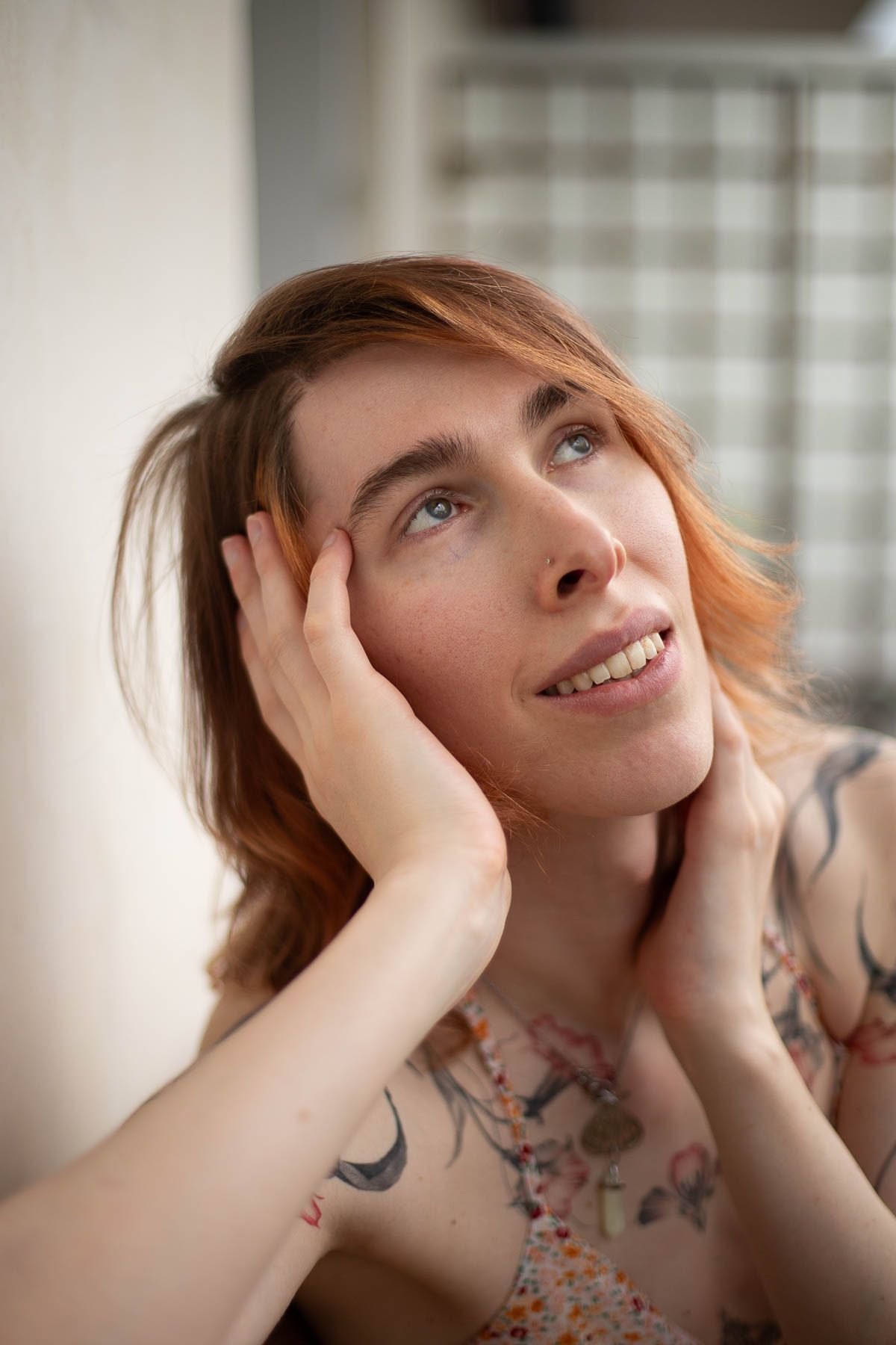 Séance photo de portrait d'une femme tatouée qui regarde vers le haut en souriant, à Tours