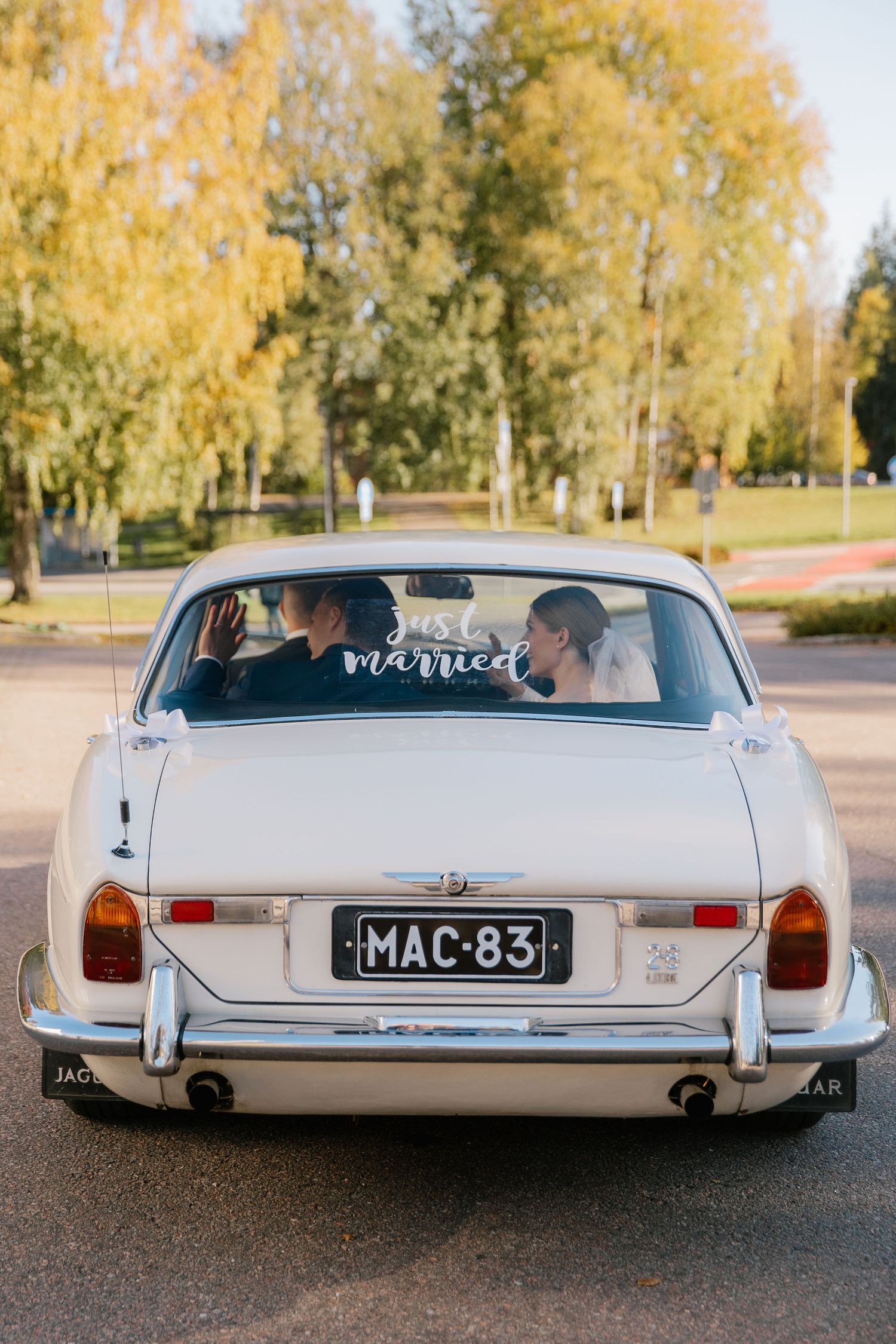 Hääpari poistuu kirkolta autolla