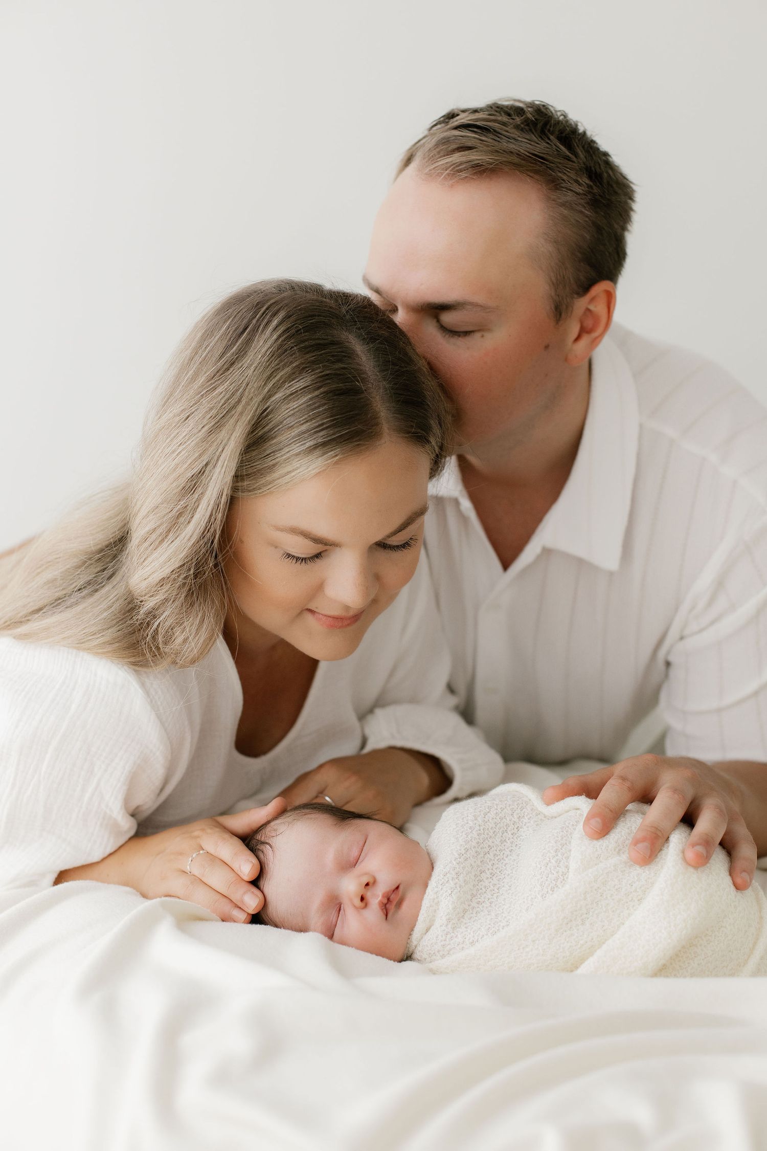 Vauva, äiti ja isä yhdessä perhekuvassa newbornkuvauksessa