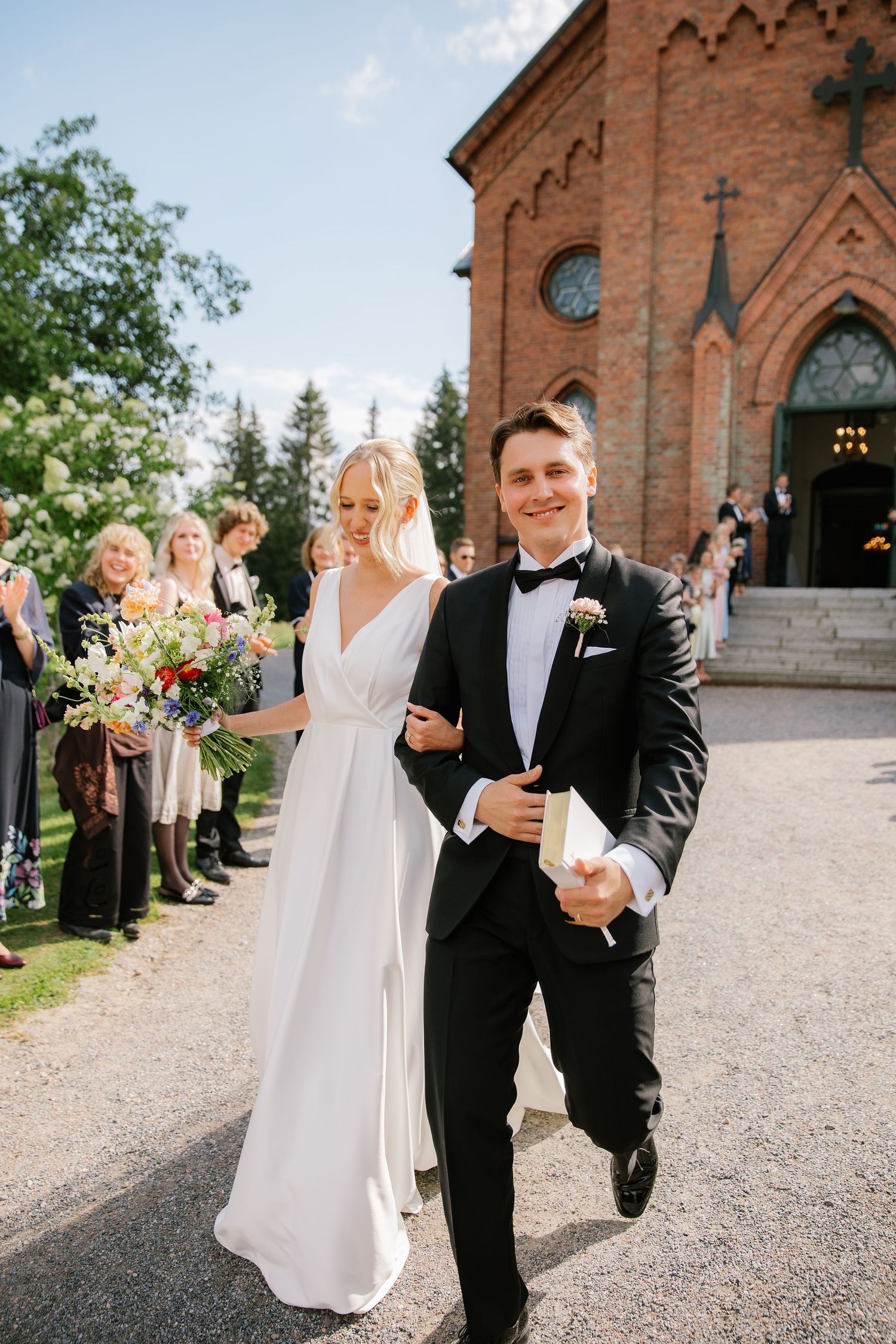 Hääpari poistuu kirkosta osana dokumentaarista hääkuvausta
