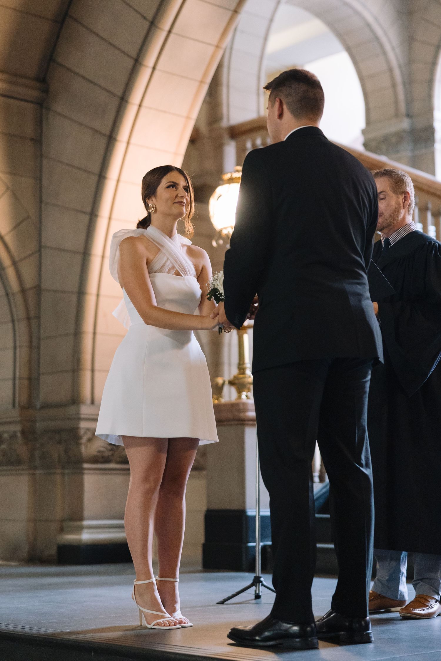 A wedding ceremony in a historic building with arched architecture and natural lighting.