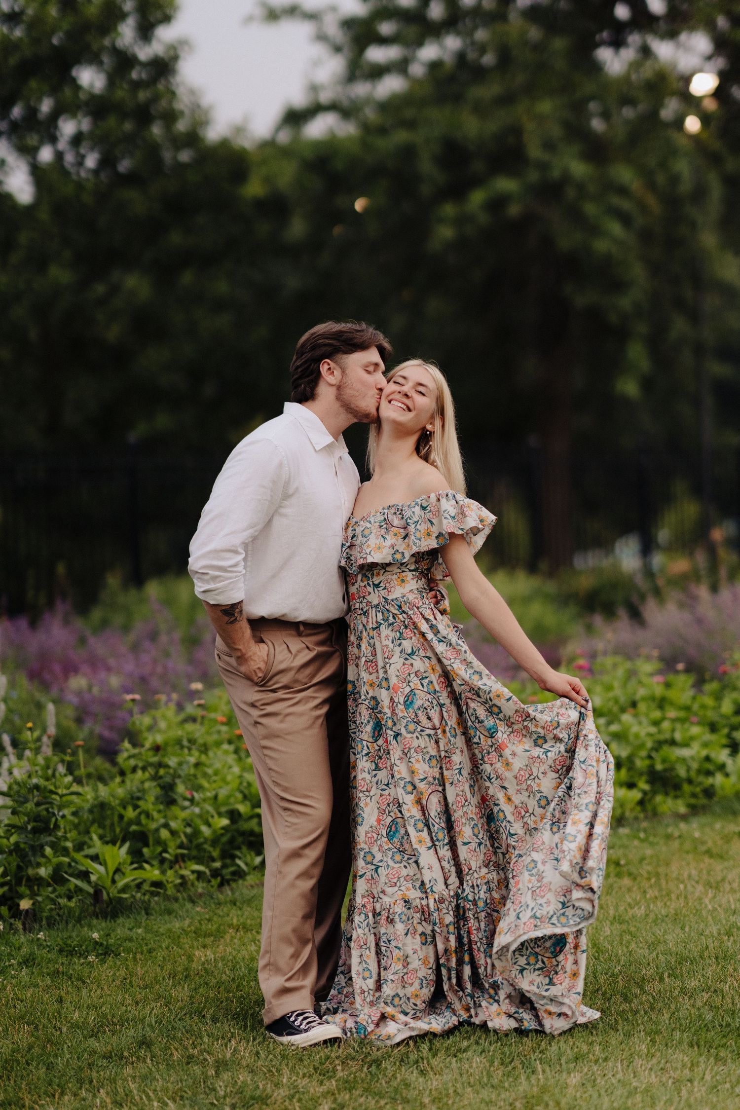 A romantic garden scene with blooming purple flowers and flowing floral dress.