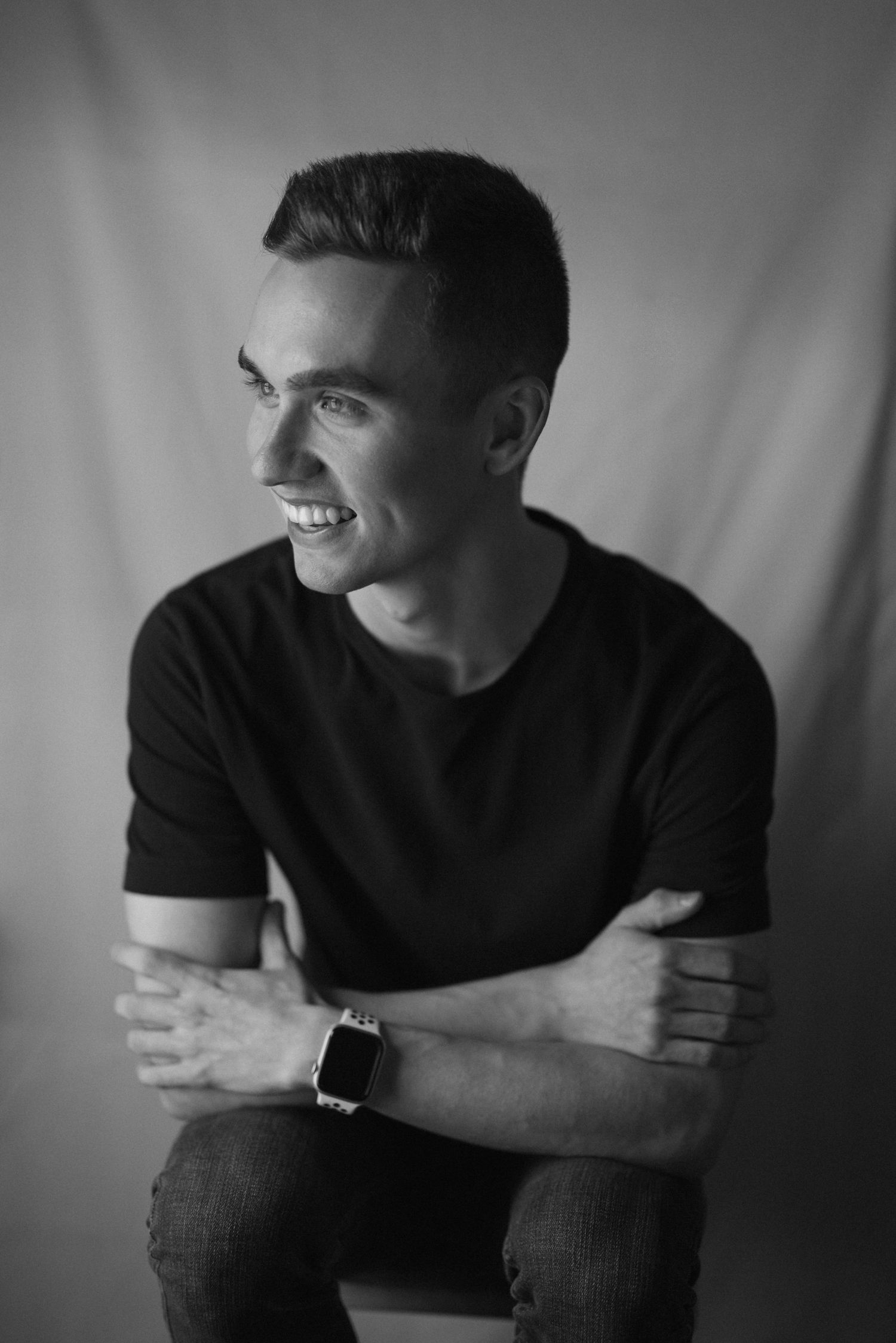 A black and white photo series showing someone in a dark shirt smiling and looking to the side against a light background.
