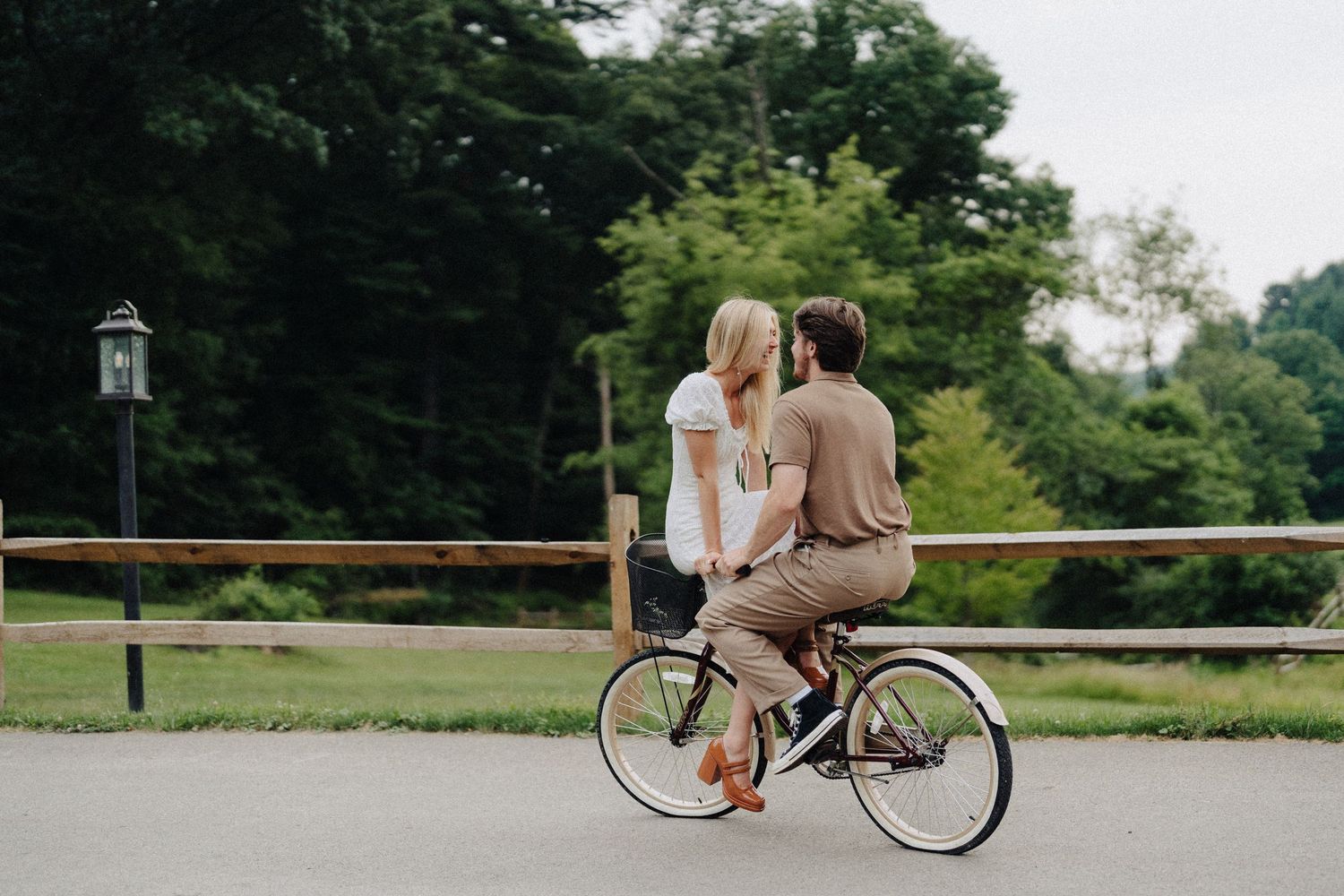A couple shares a romantic moment while sitting together on a bicycle.