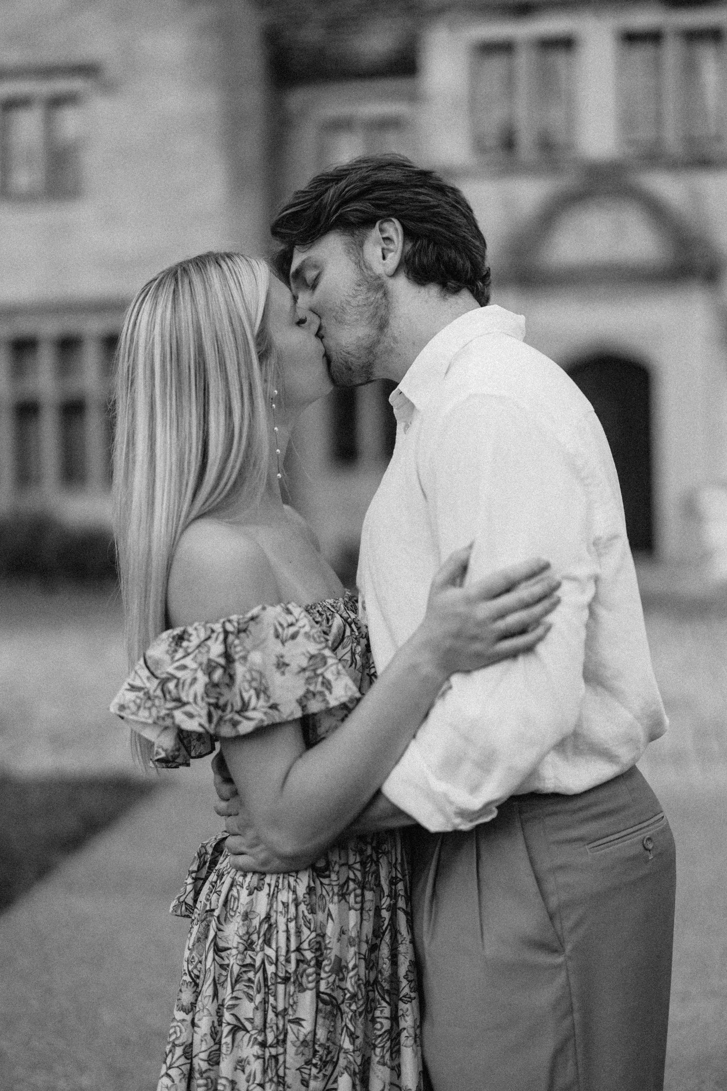 Romantic black and white moment captured between couple outside historic building.