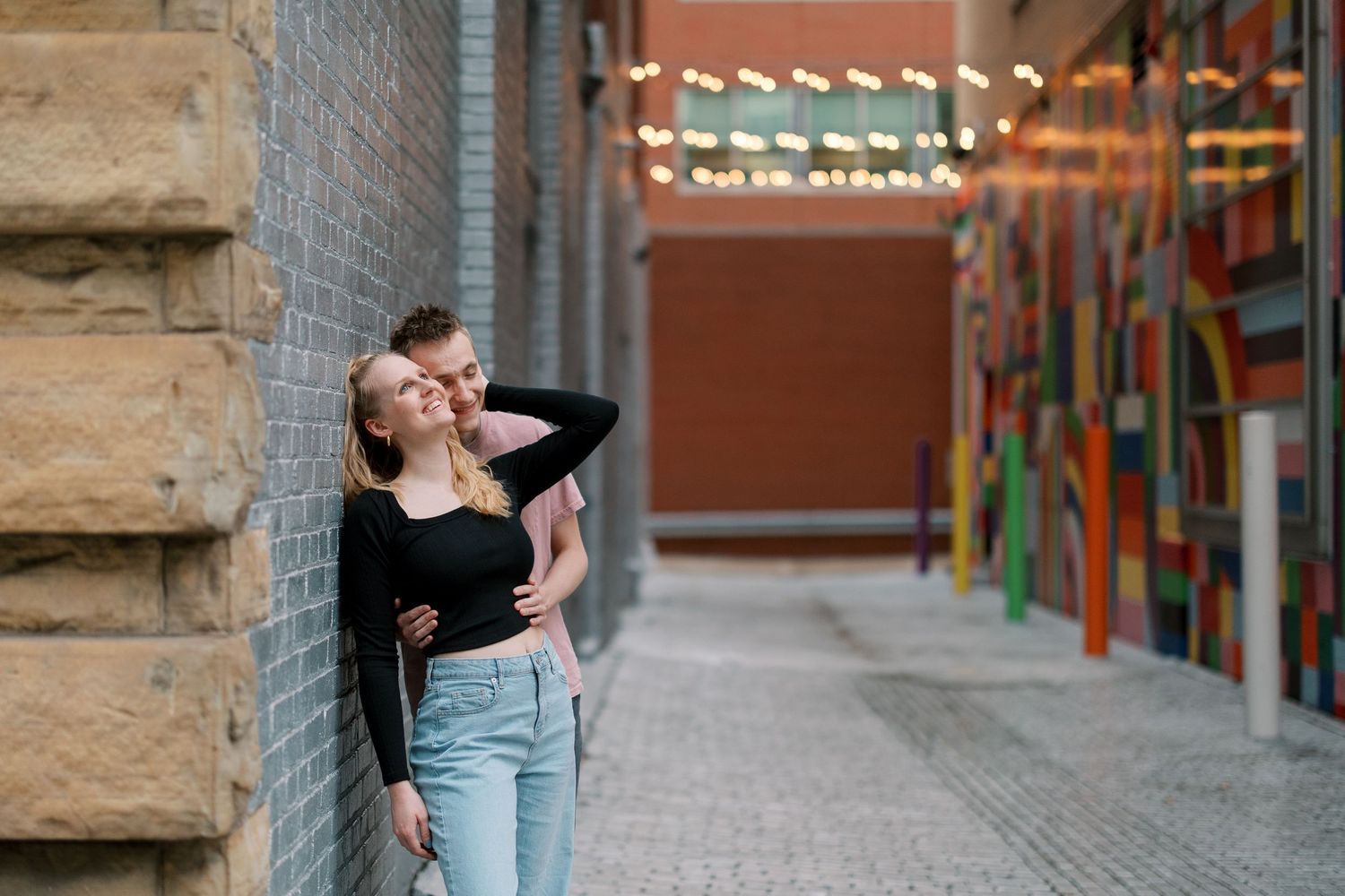 A playful fashion-forward pose against an urban backdrop with colorful street art.