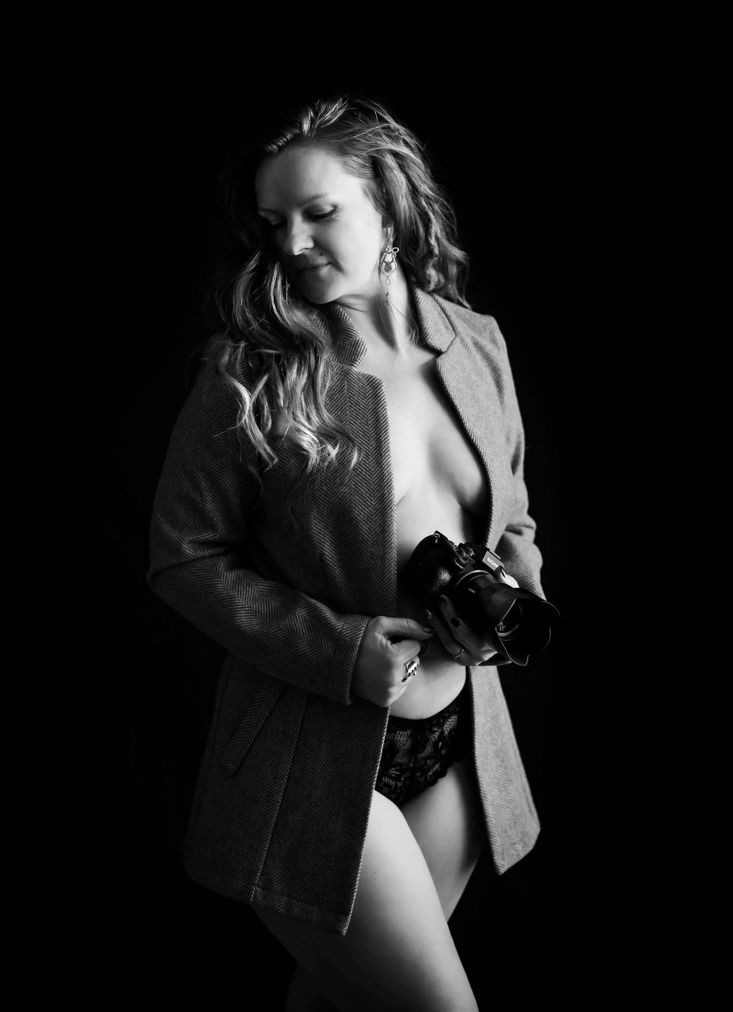 Dramatic boudoir series with pink jacket and black lingerie against dark backdrop.