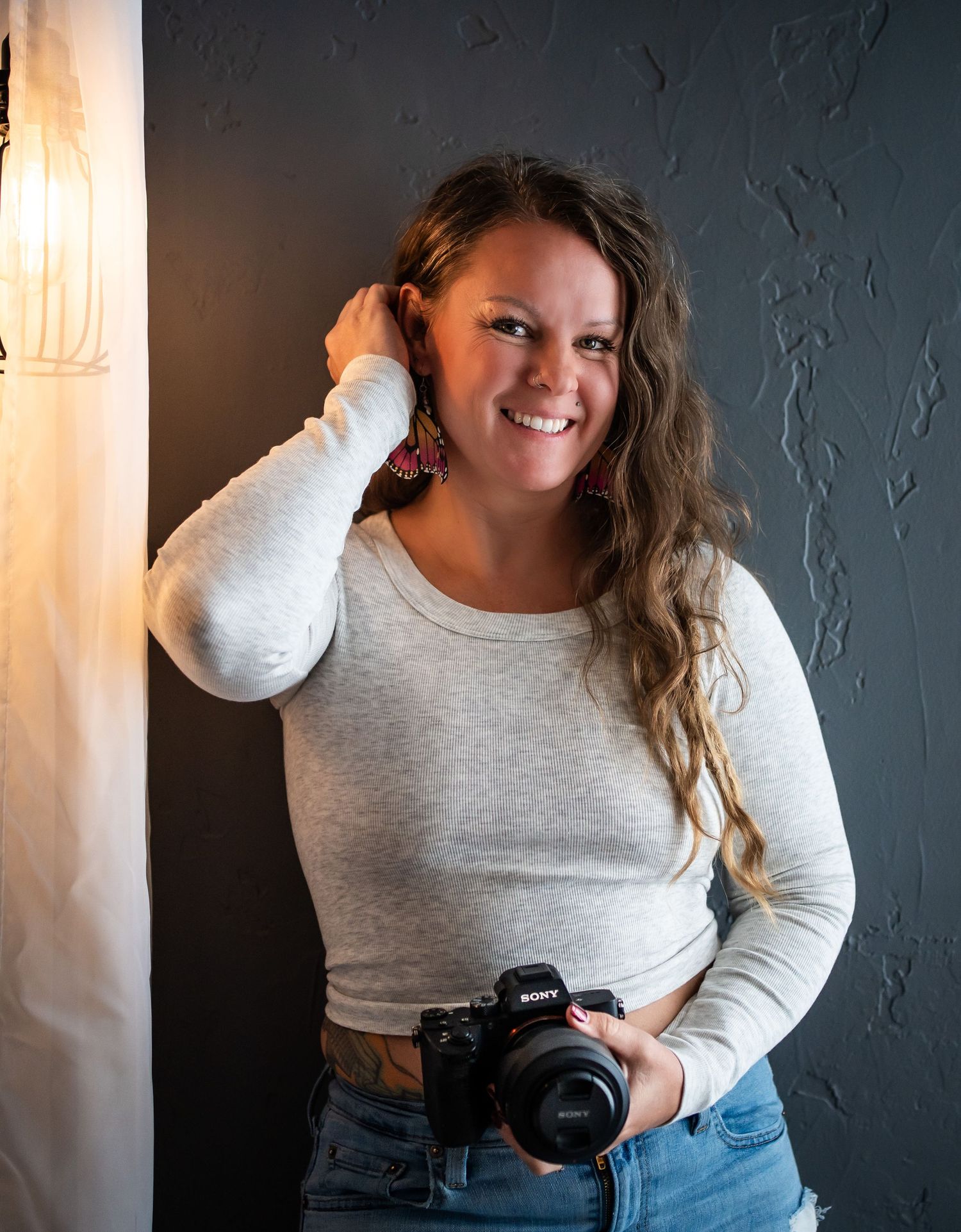 A series of four photos showing a person in a gray sweater and jeans posing casually against a dark wall.