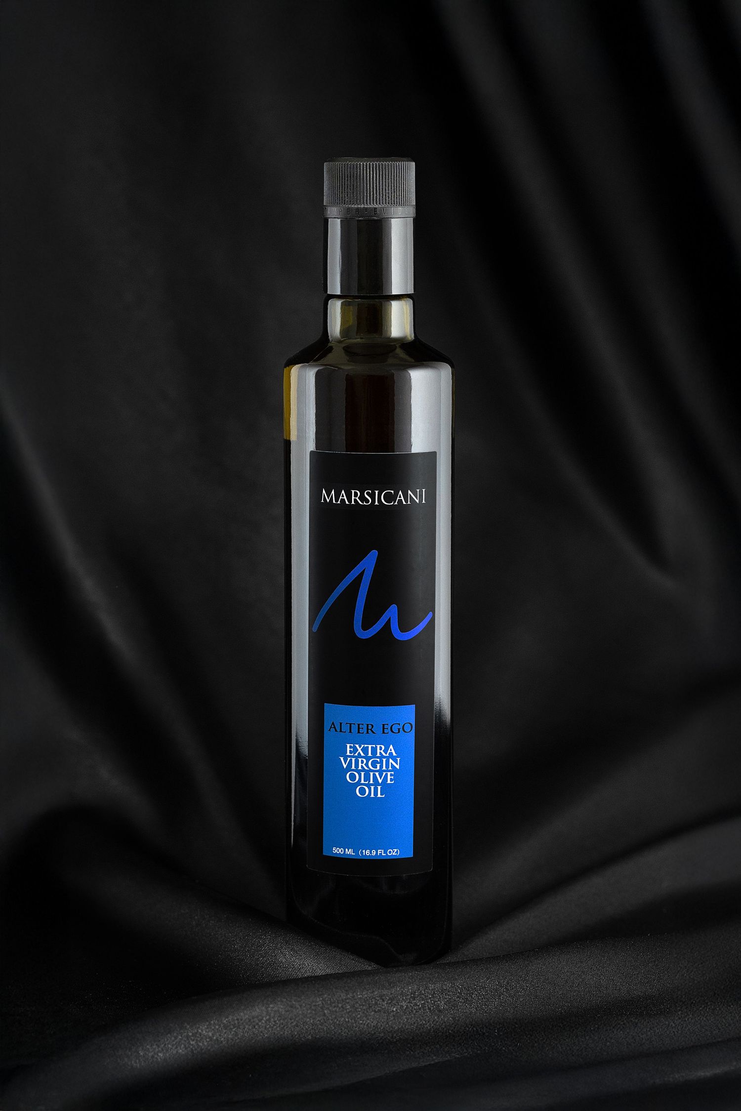 Marsicani Extra Virgin Olive Oil 500ml bottle displayed elegantly against black draped fabric.