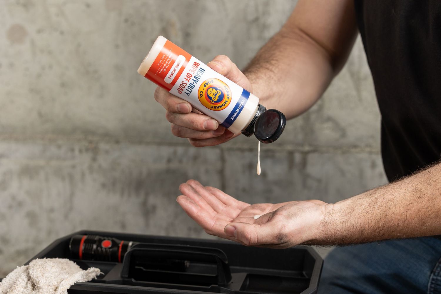 Man pouring Bunky Monkey Heavy-Duty Wipe Off Soap into palm near toolbox.