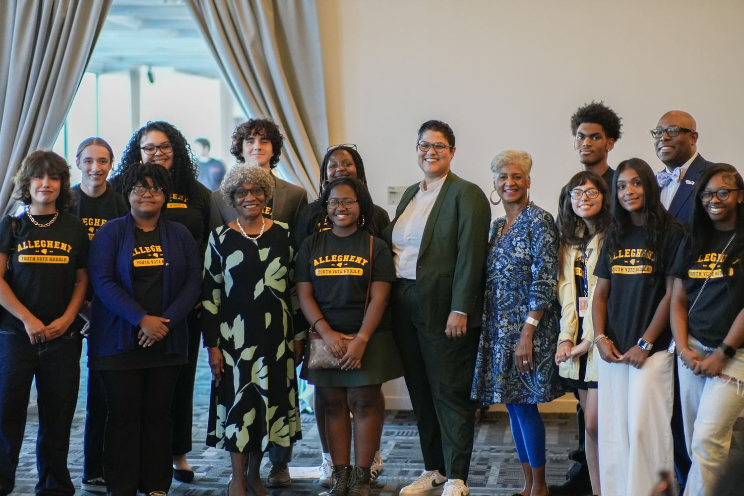 Diverse group of people posing together indoors at a formal gathering event.