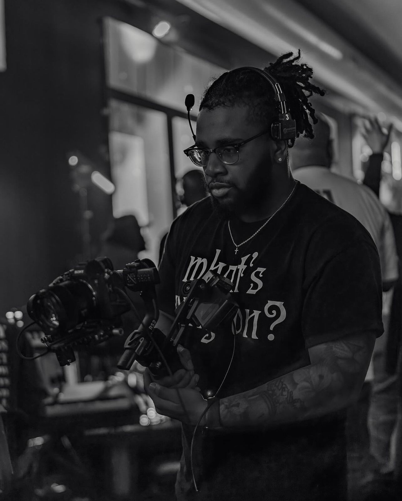 Black and white photo of a man operating a professional camera on a gimbal.