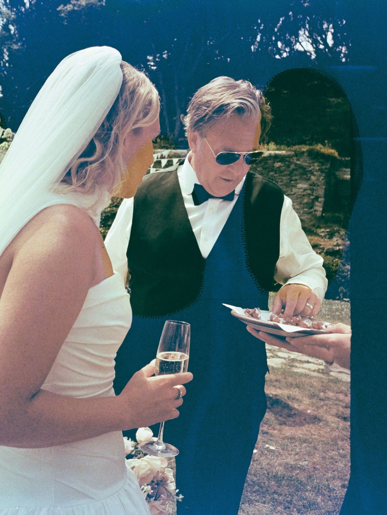 Wedding guests enjoying champagne and mingling at an outdoor celebration.