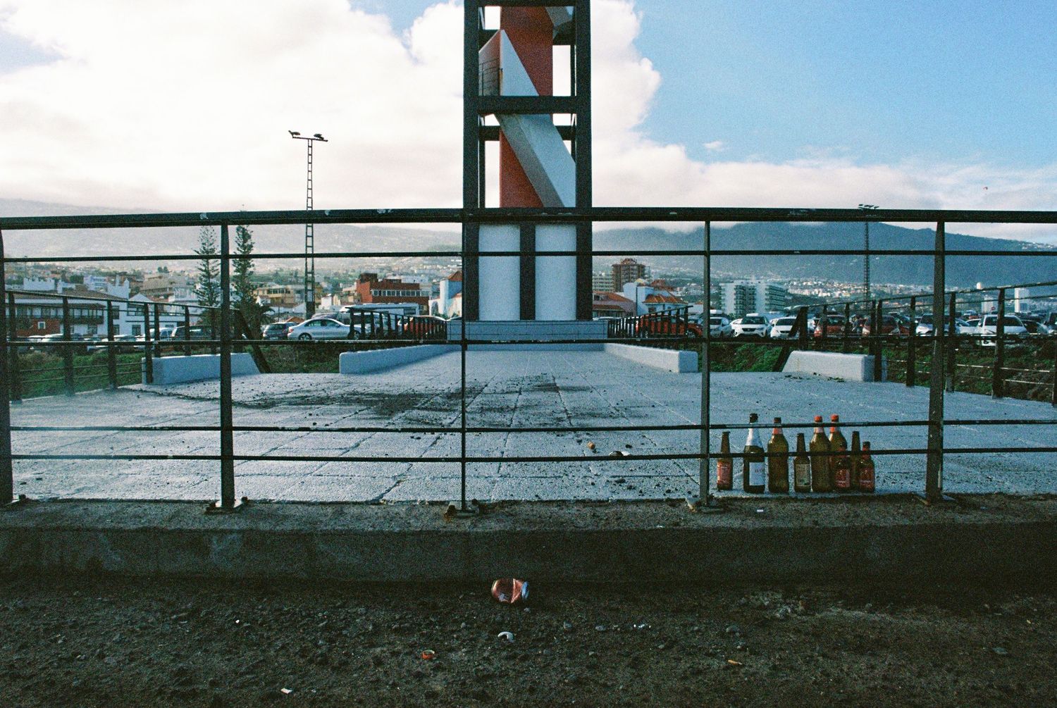 Panoramic waterfront view with industrial buildings and fencing along the shoreline.