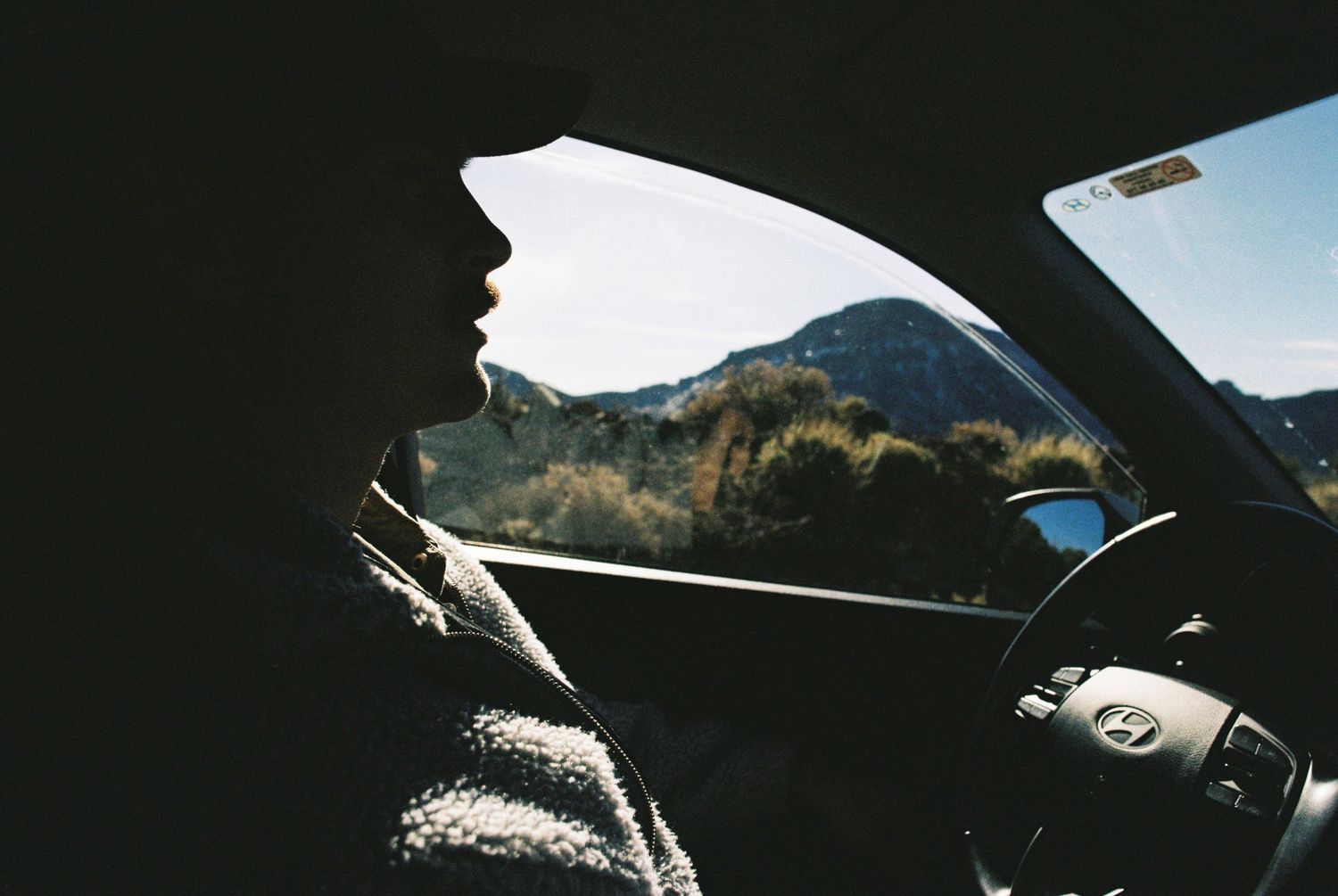 Mountain peak visible through car windshield while driving on winding road.