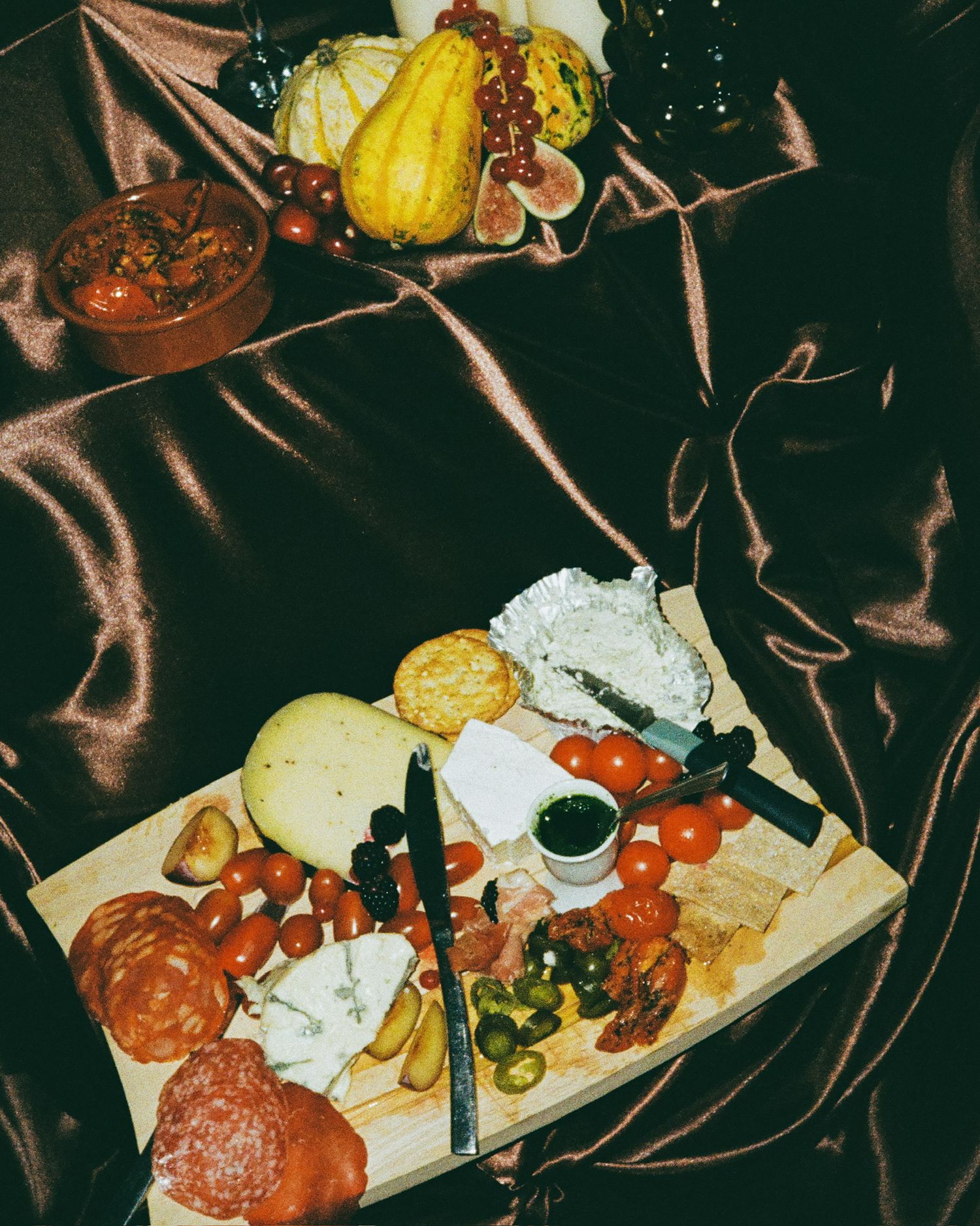 Charcuterie board with meats, cheeses and pumpkins displayed at a party.