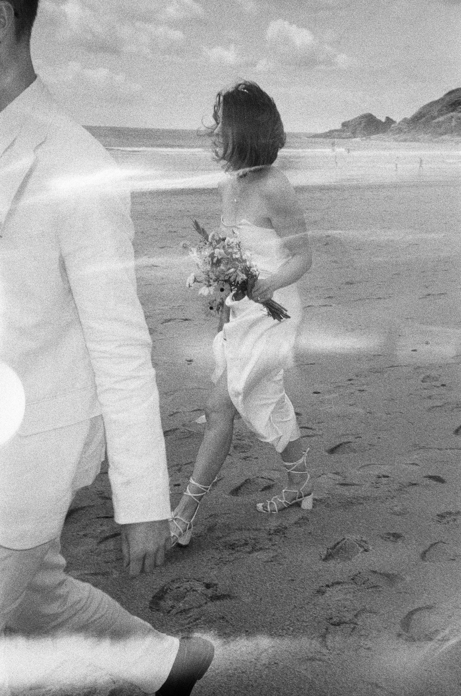 Black and white photos of people running and jumping on a sandy beach.
