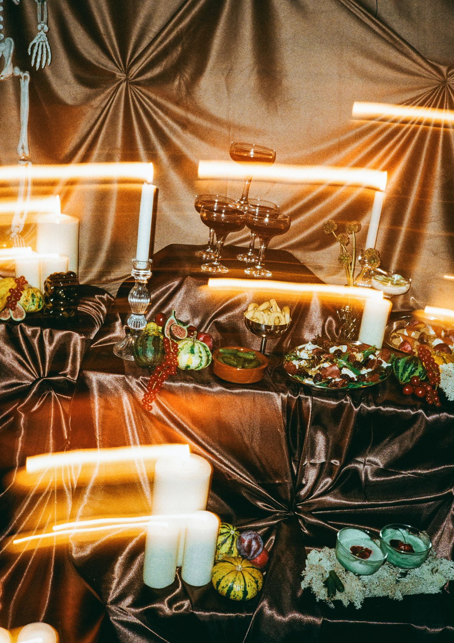 Festive Halloween table setting with glowing candles, pumpkins and spooky decorations.